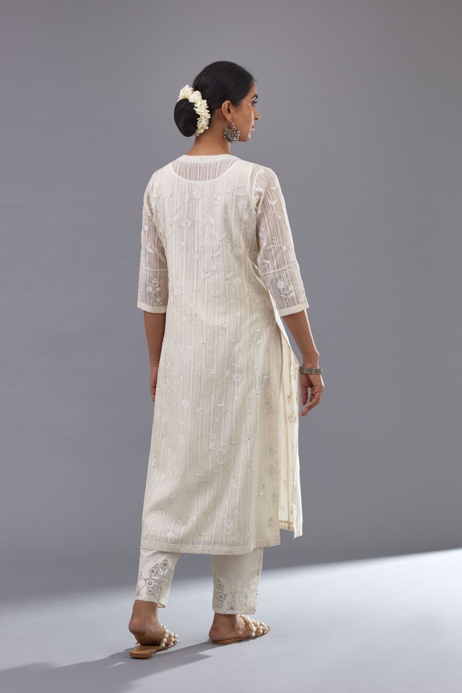 Off-white cotton chanderi kurta set with all-over jaal embroidery and small assorted flowers embroidery at side panells, highlighted with sequins handwork.