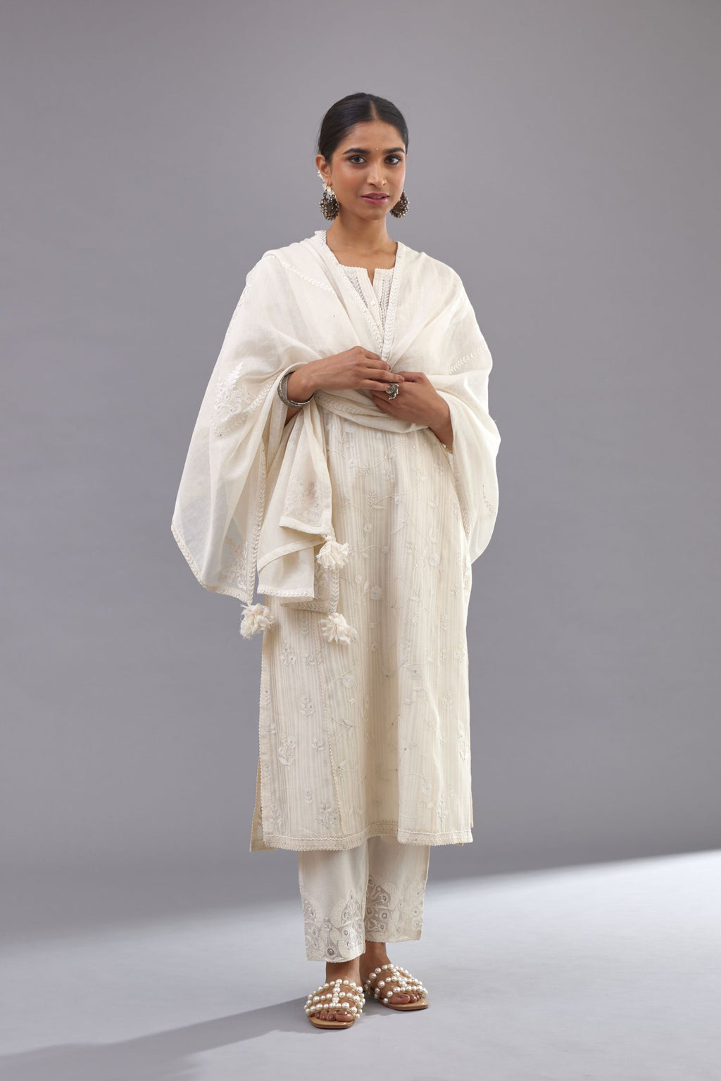 Off-white cotton chanderi kurta set with all-over jaal embroidery and small assorted flowers embroidery at side panells, highlighted with sequins handwork.