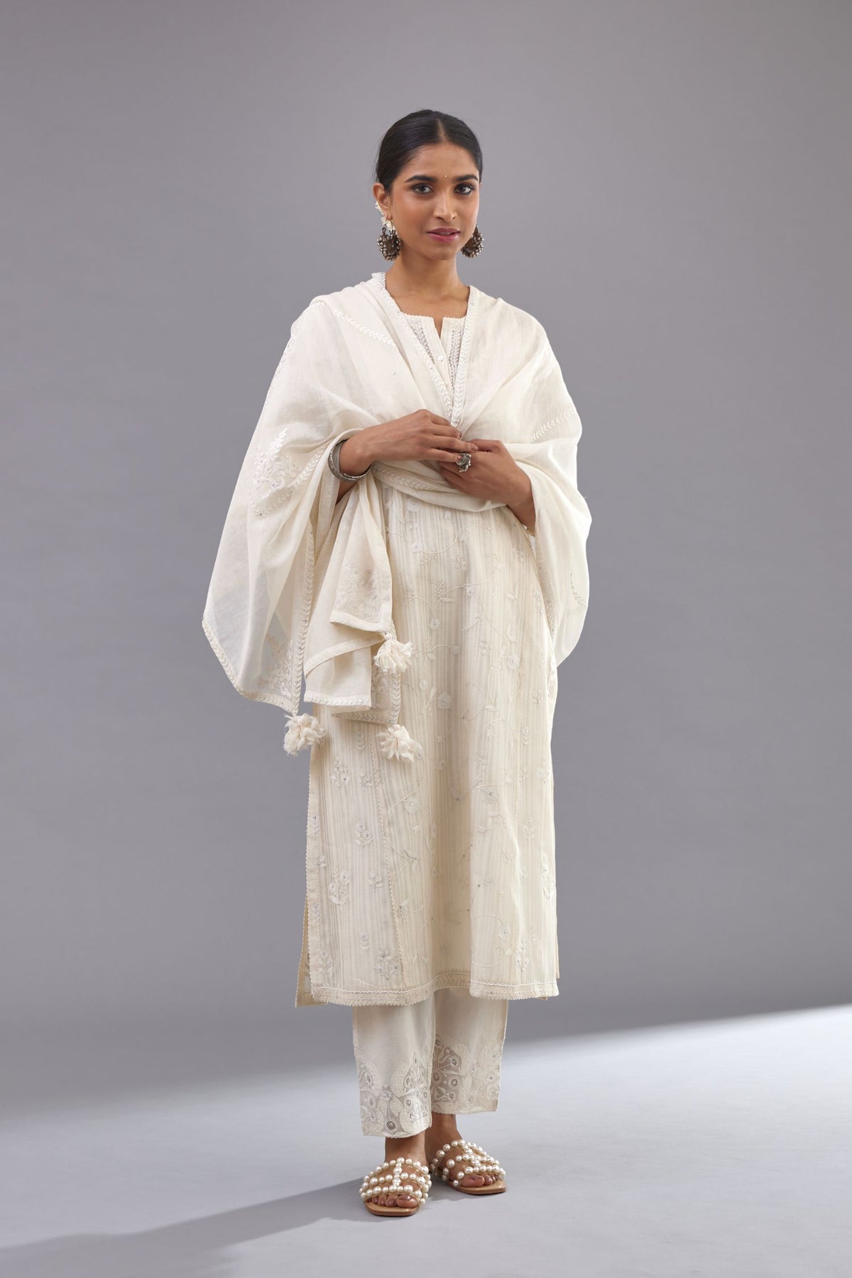 Off-white cotton chanderi kurta set with all-over jaal embroidery and small assorted flowers embroidery at side panells, highlighted with sequins handwork.