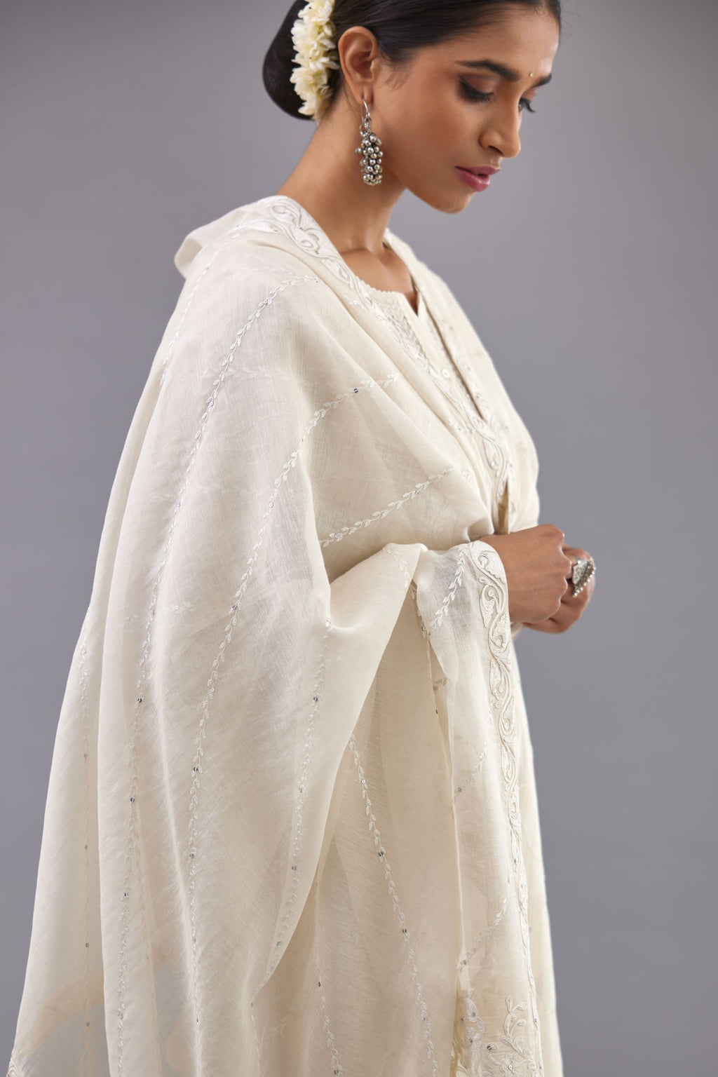Off-white cotton chanderi kurta set with all-over jaal embroidery and small assorted flowers embroidery at side panells, highlighted with sequins handwork.