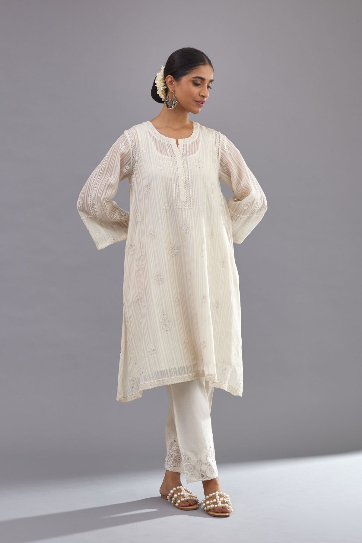 Off-white cotton chanderi A-line kurta set with all-over assorted flowers embroidery, highlighted with sequins handwork.