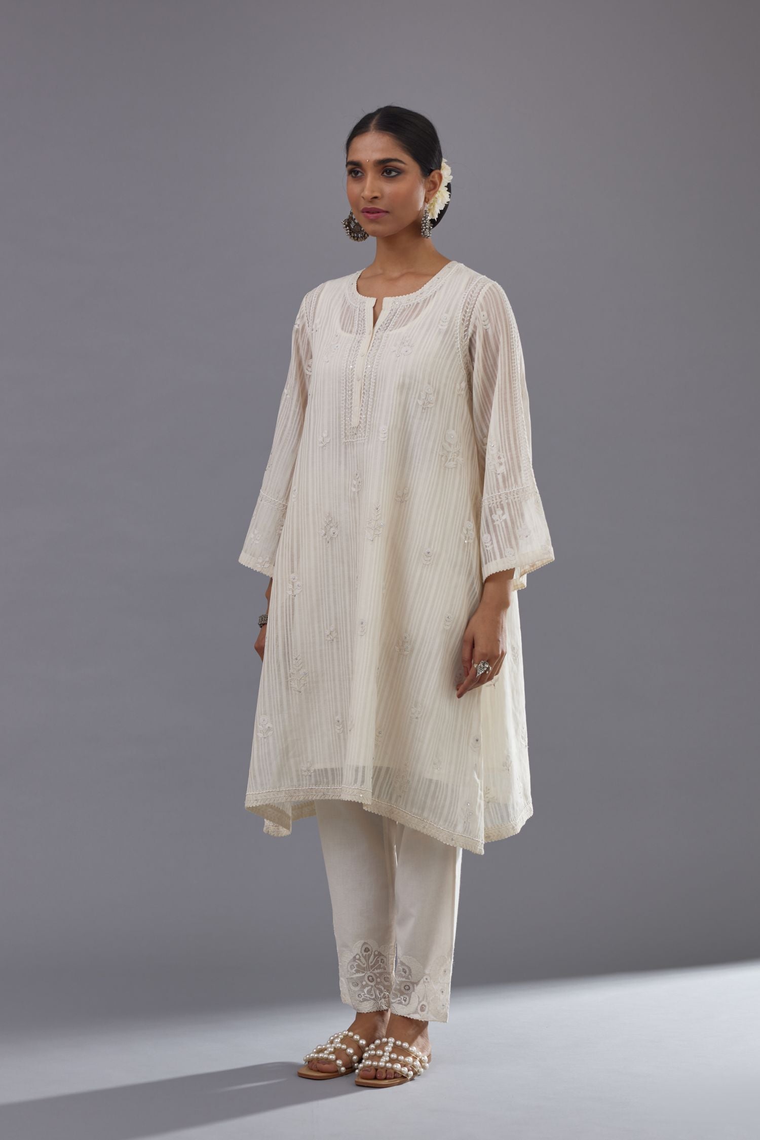 Off-white cotton chanderi A-line kurta set with all-over assorted flowers embroidery, highlighted with sequins handwork.