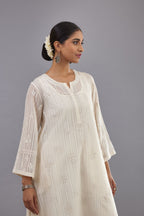 Off-white cotton chanderi A-line kurta set with all-over assorted flowers embroidery, highlighted with sequins handwork.