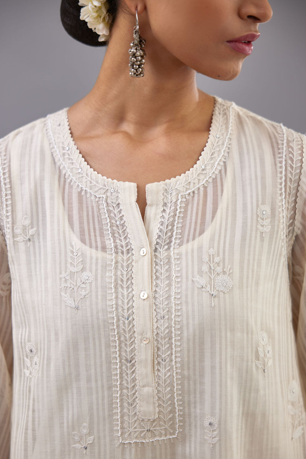 Off-white cotton chanderi A-line kurta set with all-over assorted flowers embroidery, highlighted with sequins handwork.