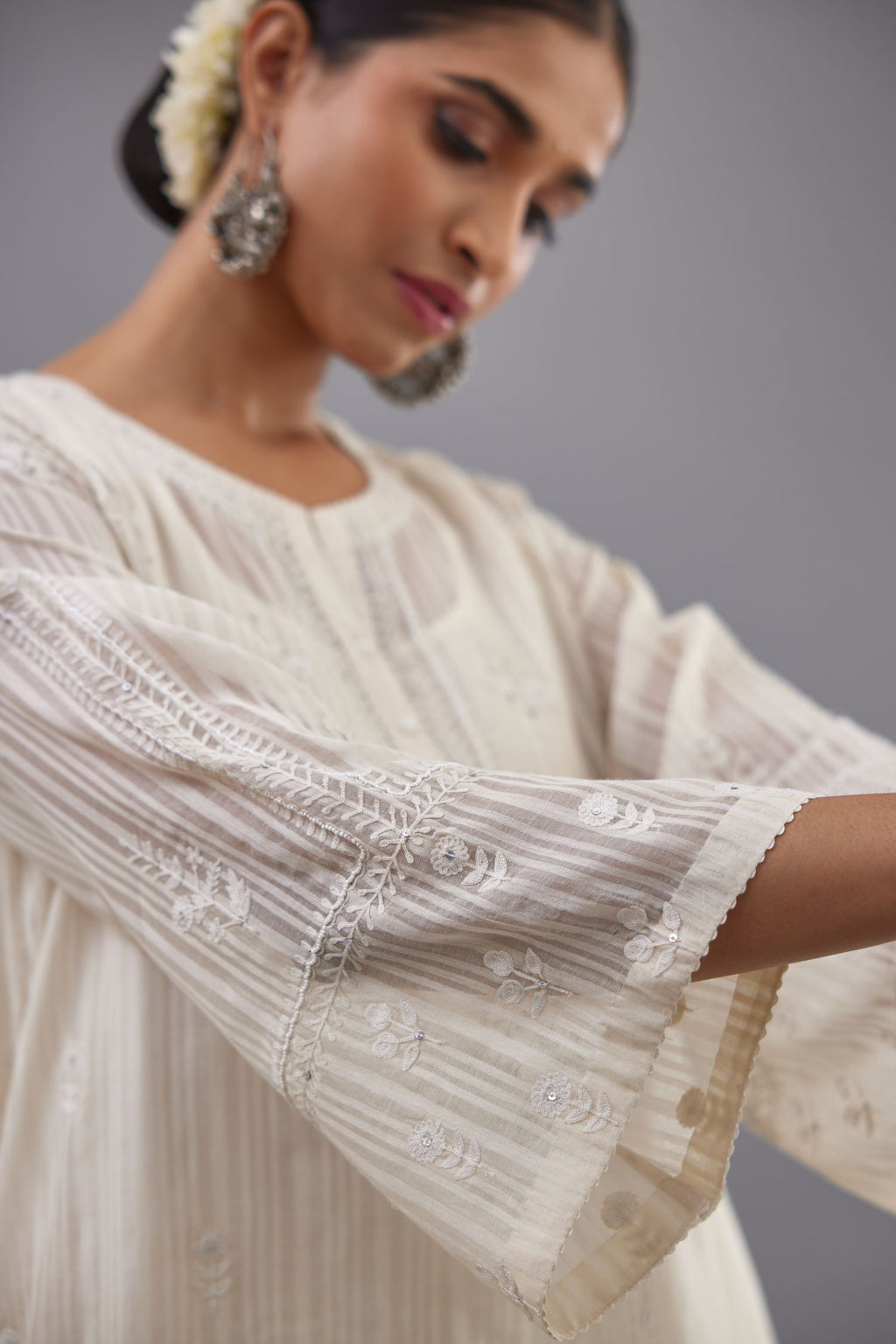 Off-white cotton chanderi A-line kurta set with all-over assorted flowers embroidery, highlighted with sequins handwork.