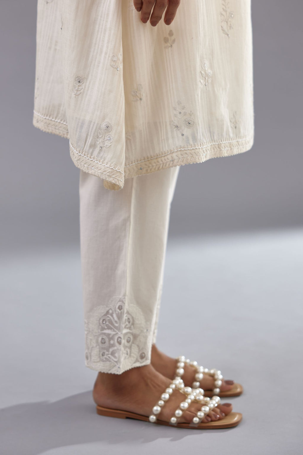 Off-white cotton chanderi A-line kurta set with all-over assorted flowers embroidery, highlighted with sequins handwork.