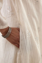 Off-white cotton chanderi A-line kurta set with all-over assorted flowers embroidery, highlighted with sequins handwork.