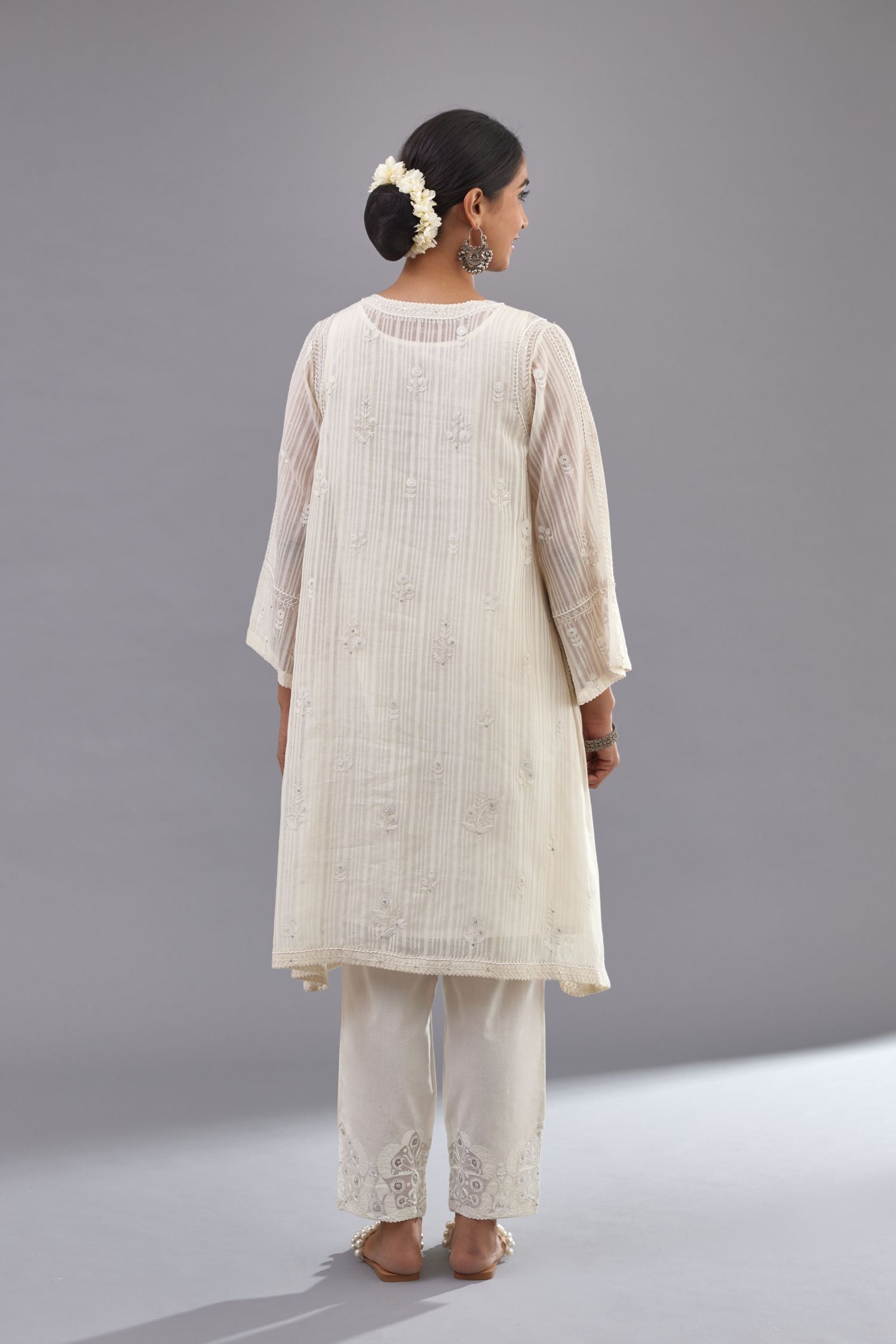 Off-white cotton chanderi A-line kurta set with all-over assorted flowers embroidery, highlighted with sequins handwork.