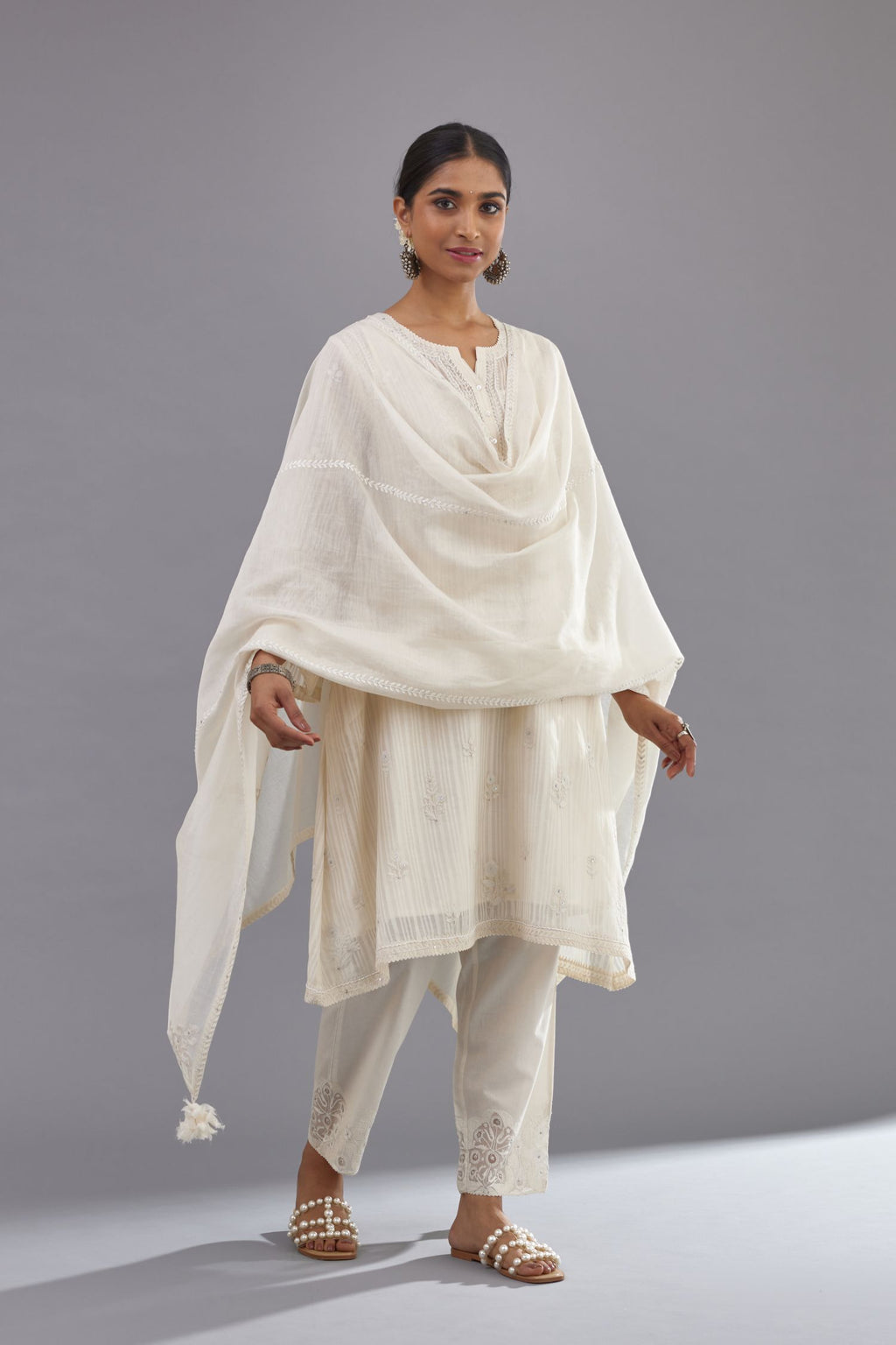 Off-white cotton chanderi A-line kurta set with all-over assorted flowers embroidery, highlighted with sequins handwork.