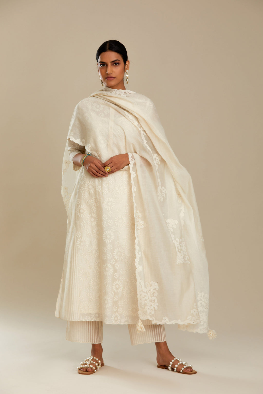 Off white silk chanderi straight kurta set with floral appliqué in center panel and striped cutwork at the sides.