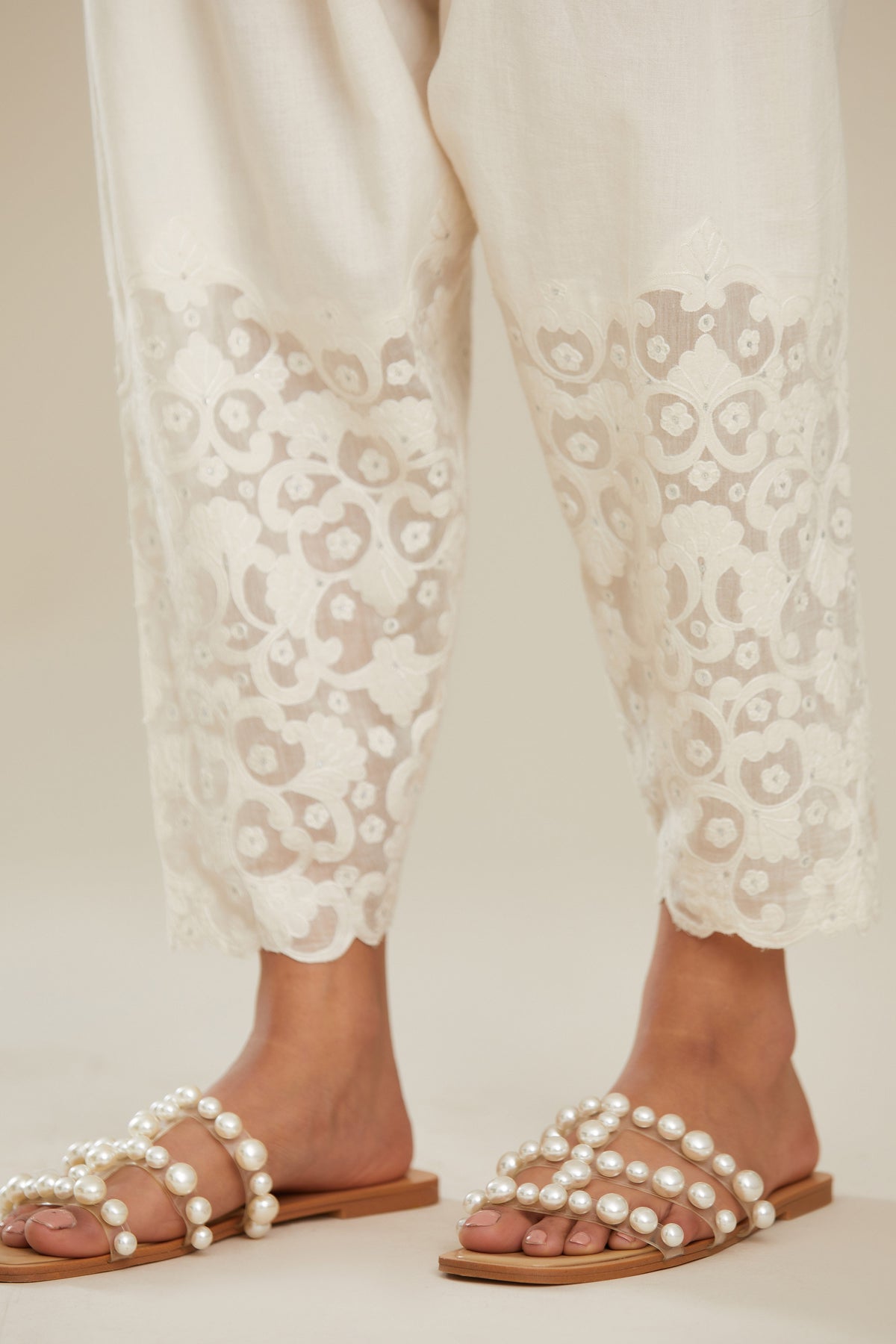 Off white cotton narrow salwar with appliqué and hand attached sequins detailing. (Salwar)