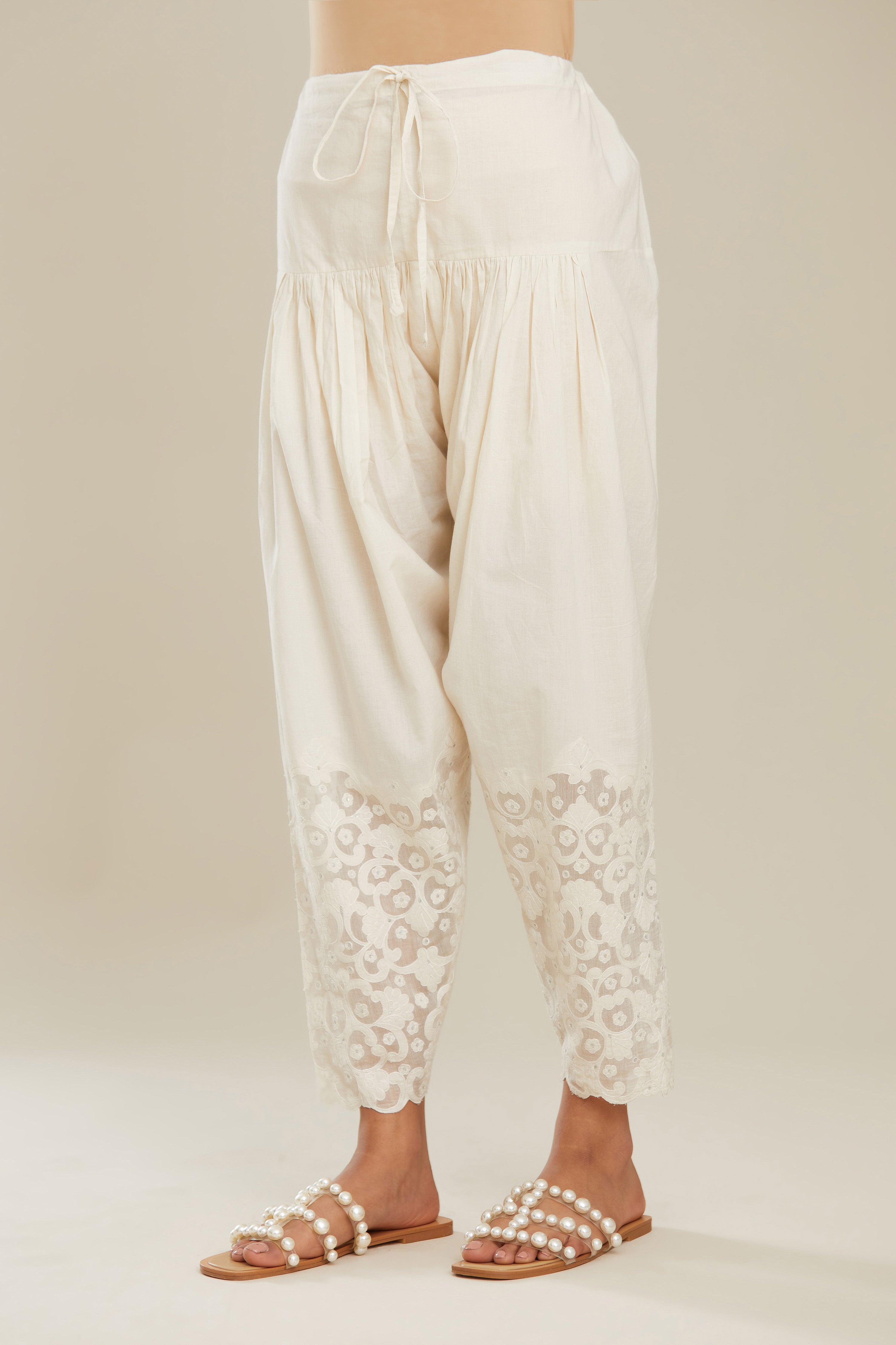Off white cotton narrow salwar with appliqué and hand attached sequins detailing. (Salwar)