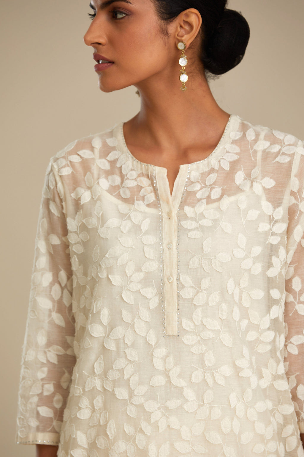 Off white silk chanderi straight kurta set with all-over leaf appliqué and sequins at edges.
