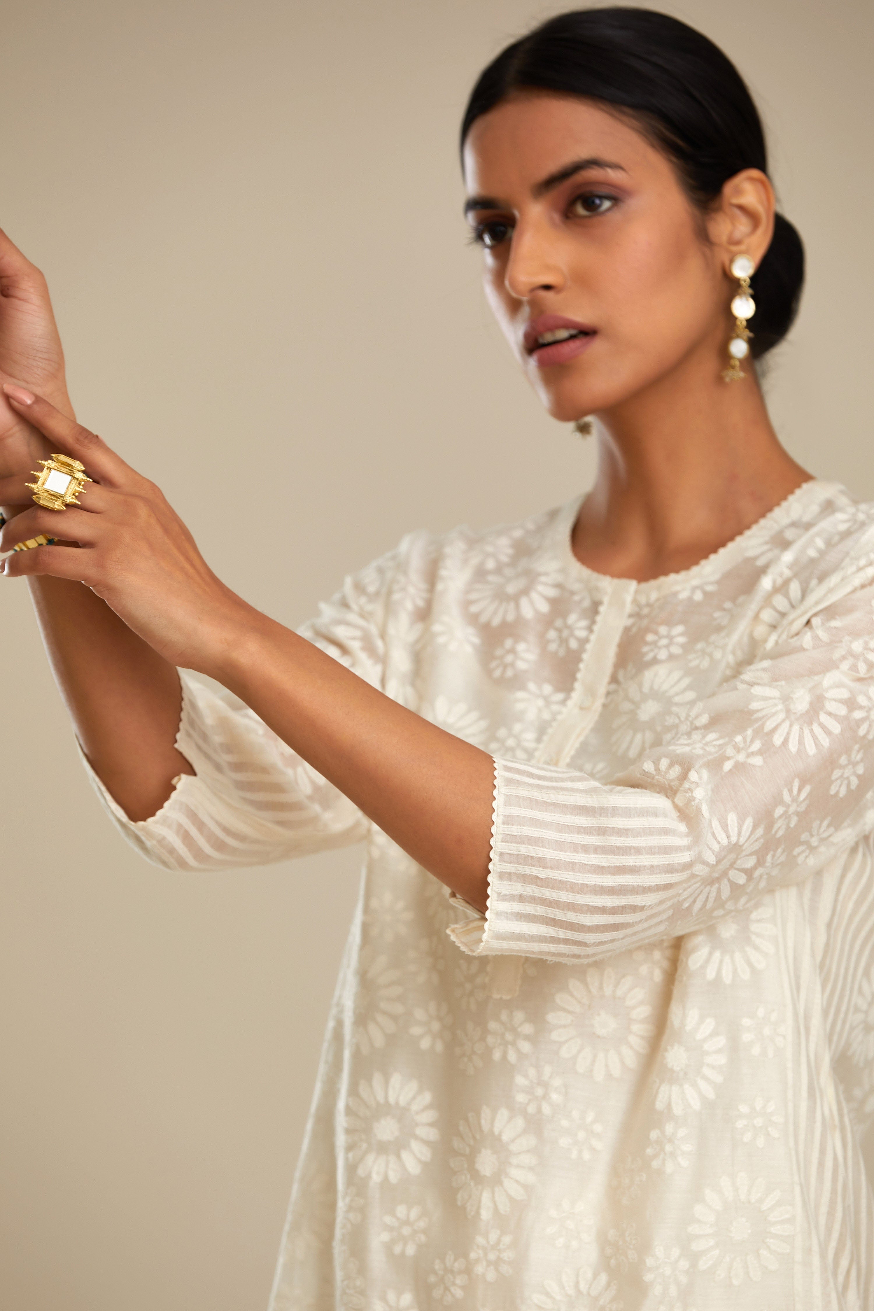 Off white silk chanderi straight kurta set with floral appliqué in center panel and striped cutwork at the sides.