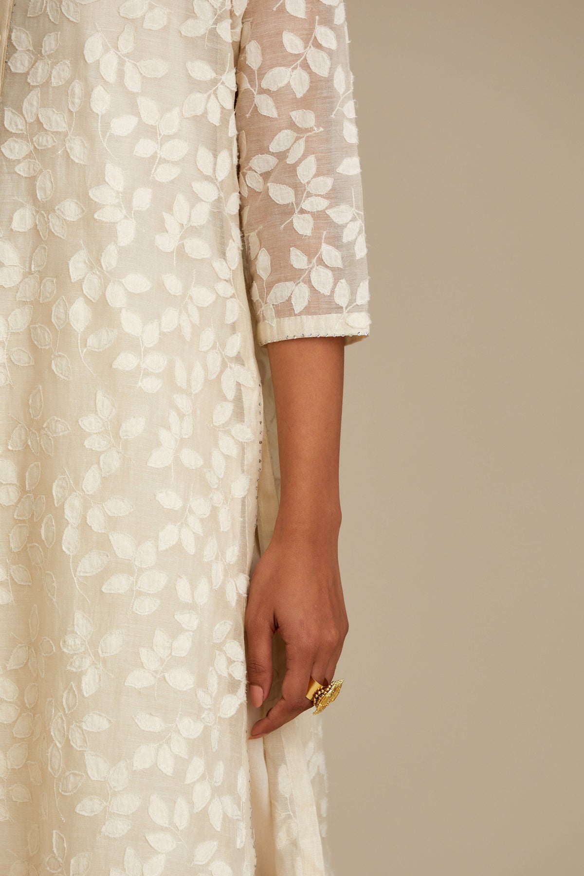 Off white silk chanderi straight kurta set with all-over leaf appliqué and sequins at edges.