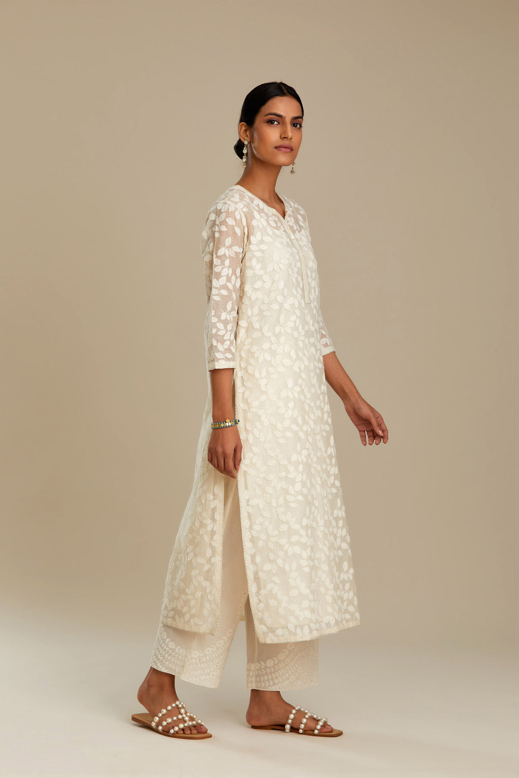 Off white silk chanderi straight kurta set with all-over leaf appliqué and sequins at edges.