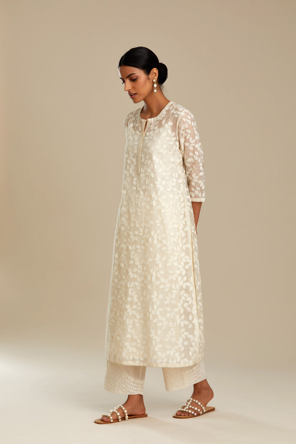 Off white silk chanderi straight kurta set with all-over leaf appliqué and sequins at edges.