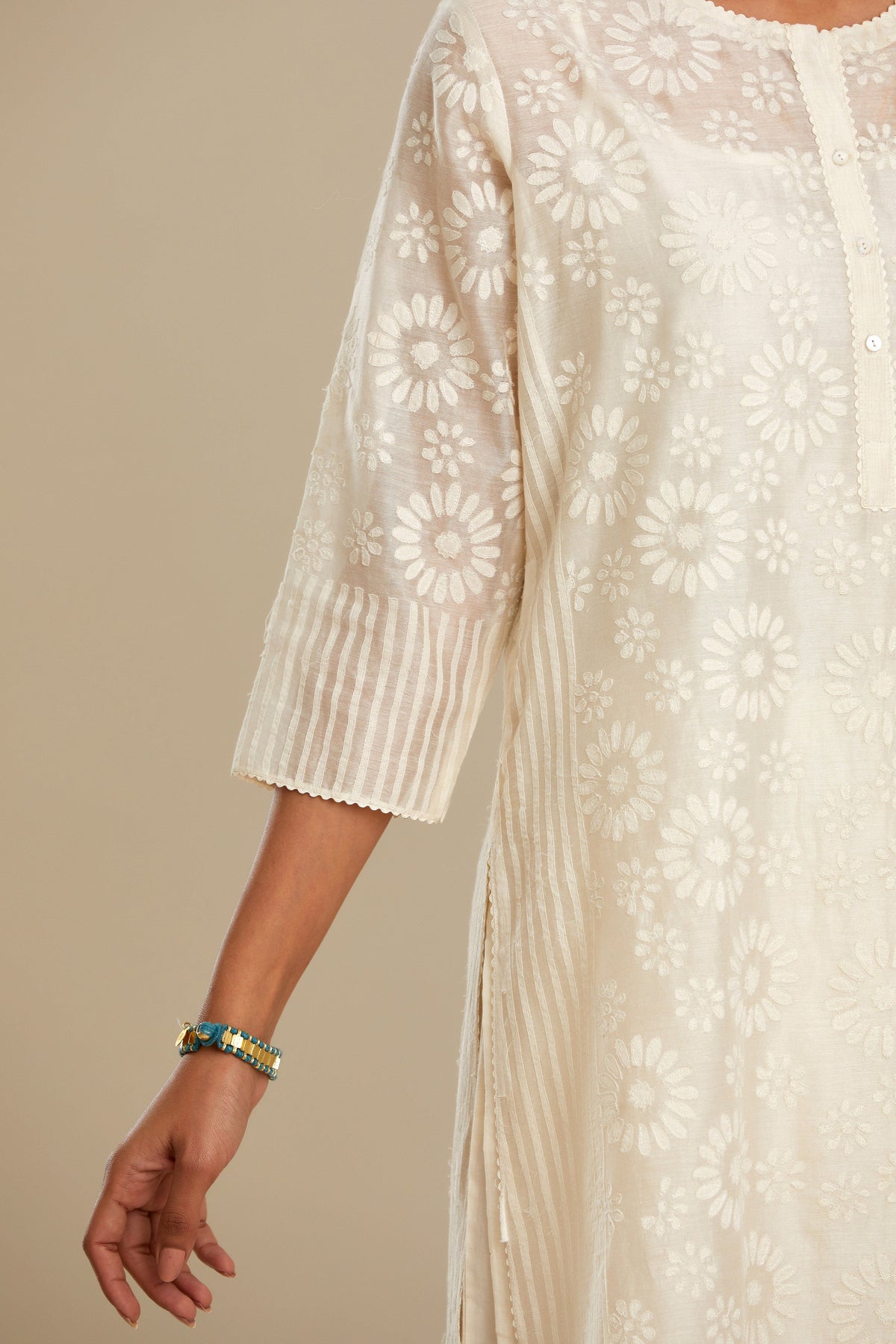 Off white silk chanderi straight kurta set with floral appliqué in center panel and striped cutwork at the sides.