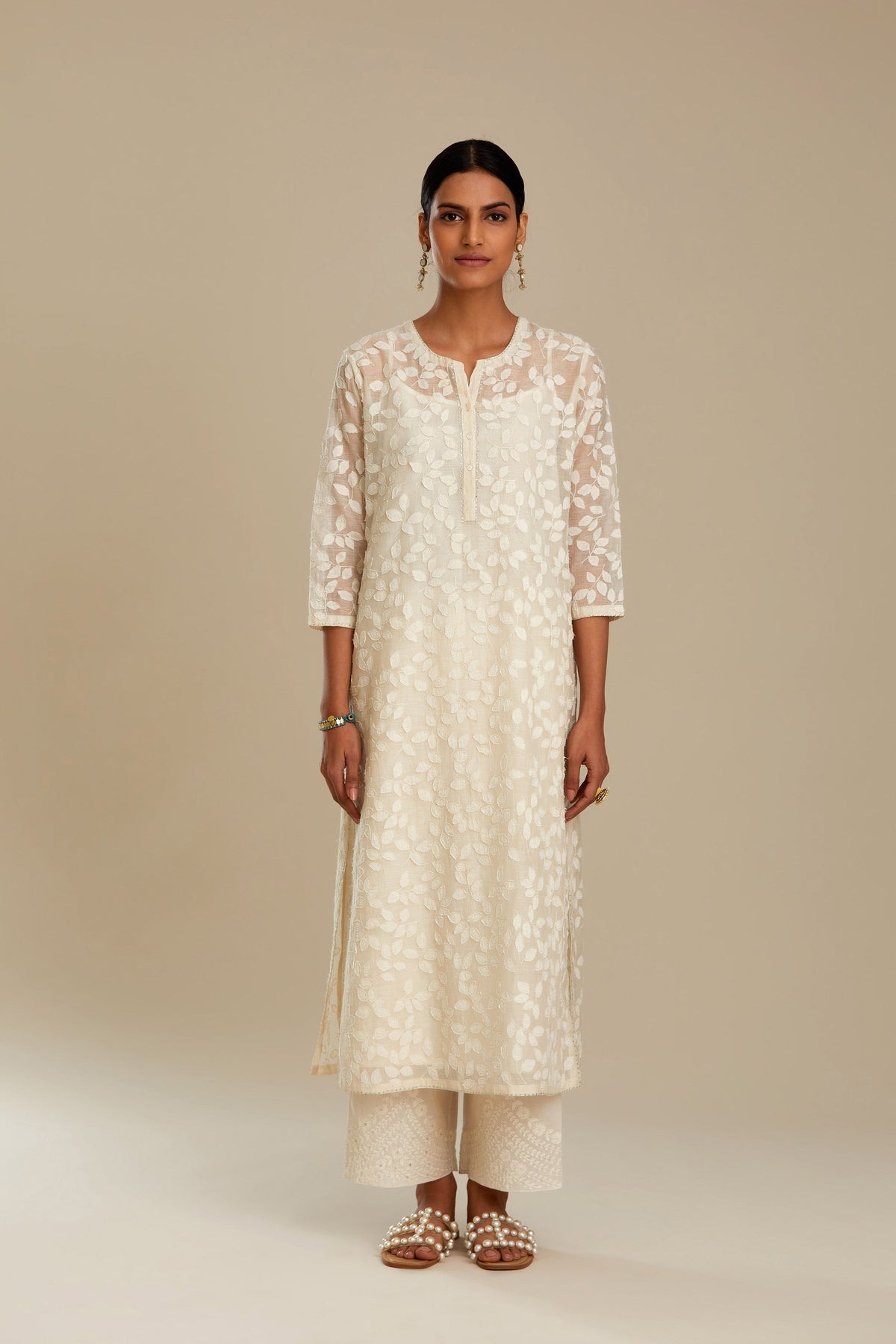 Off white silk chanderi straight kurta set with all-over leaf appliqué and sequins at edges.