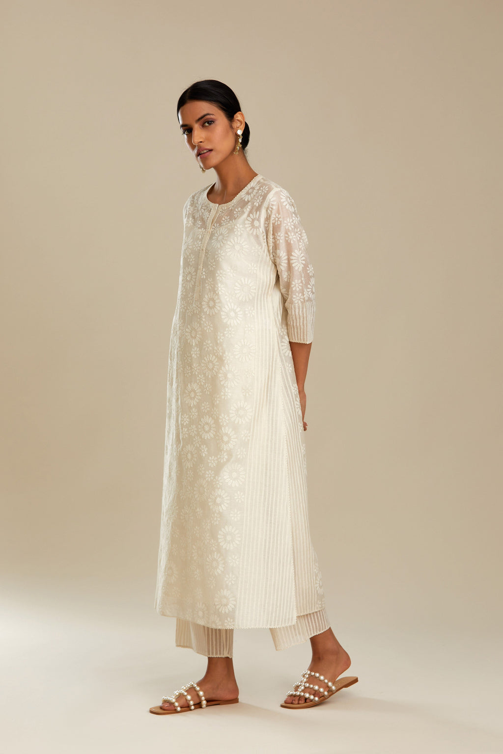 Off white silk chanderi straight kurta set with floral appliqué in center panel and striped cutwork at the sides.