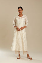 Off white silk chanderi straight kurta set with floral appliqué in center panel and striped cutwork at the sides.