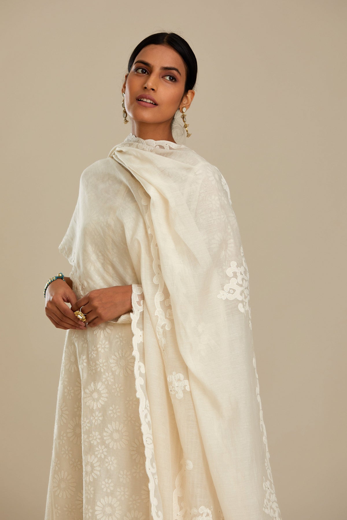 Off white silk chanderi straight kurta set with floral appliqué in center panel and striped cutwork at the sides.