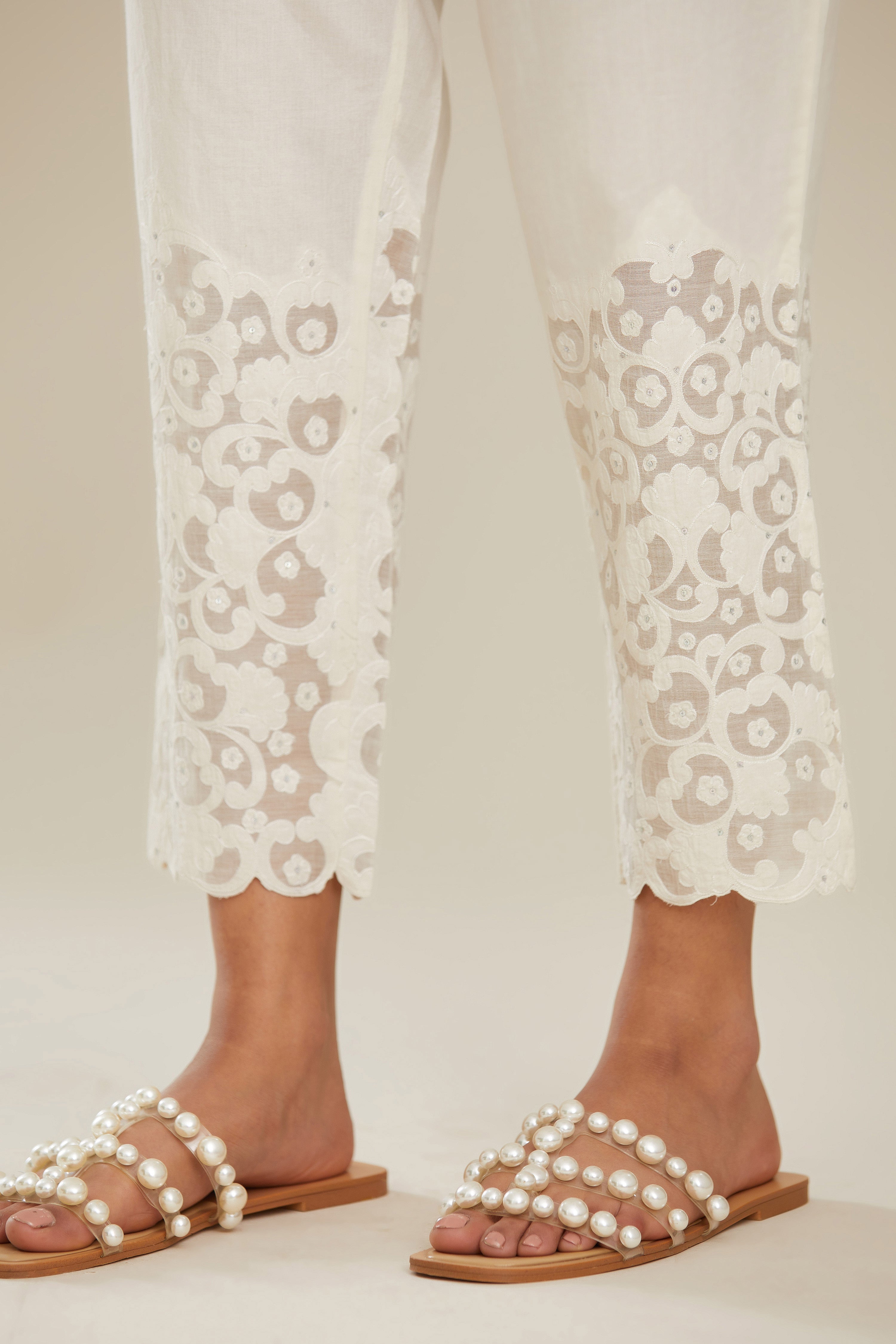 Off white cotton narrow pants with appliqué and hand attached sequins detailing. (Pants)