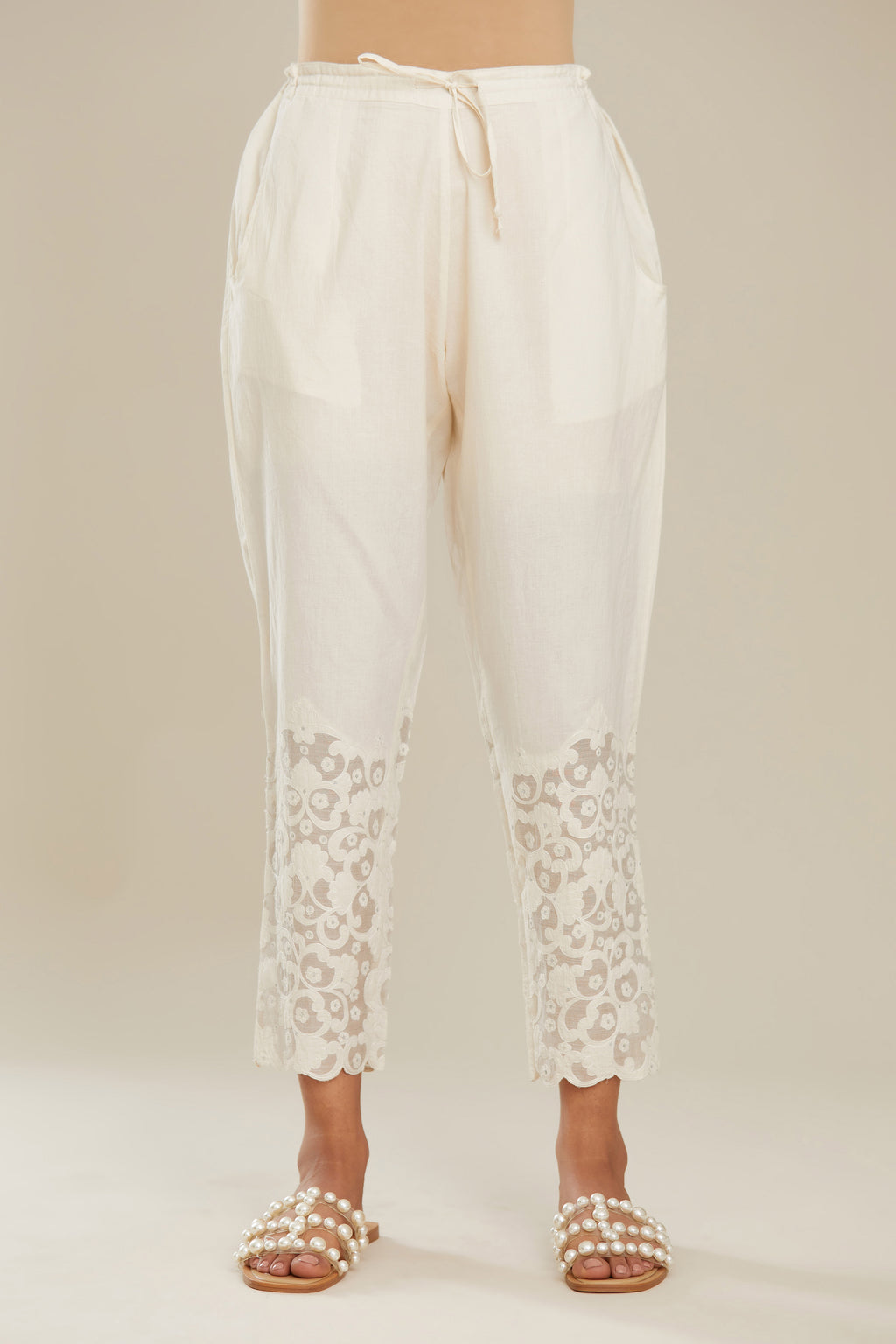Off white cotton narrow pants with appliqué and hand attached sequins detailing. (Pants)