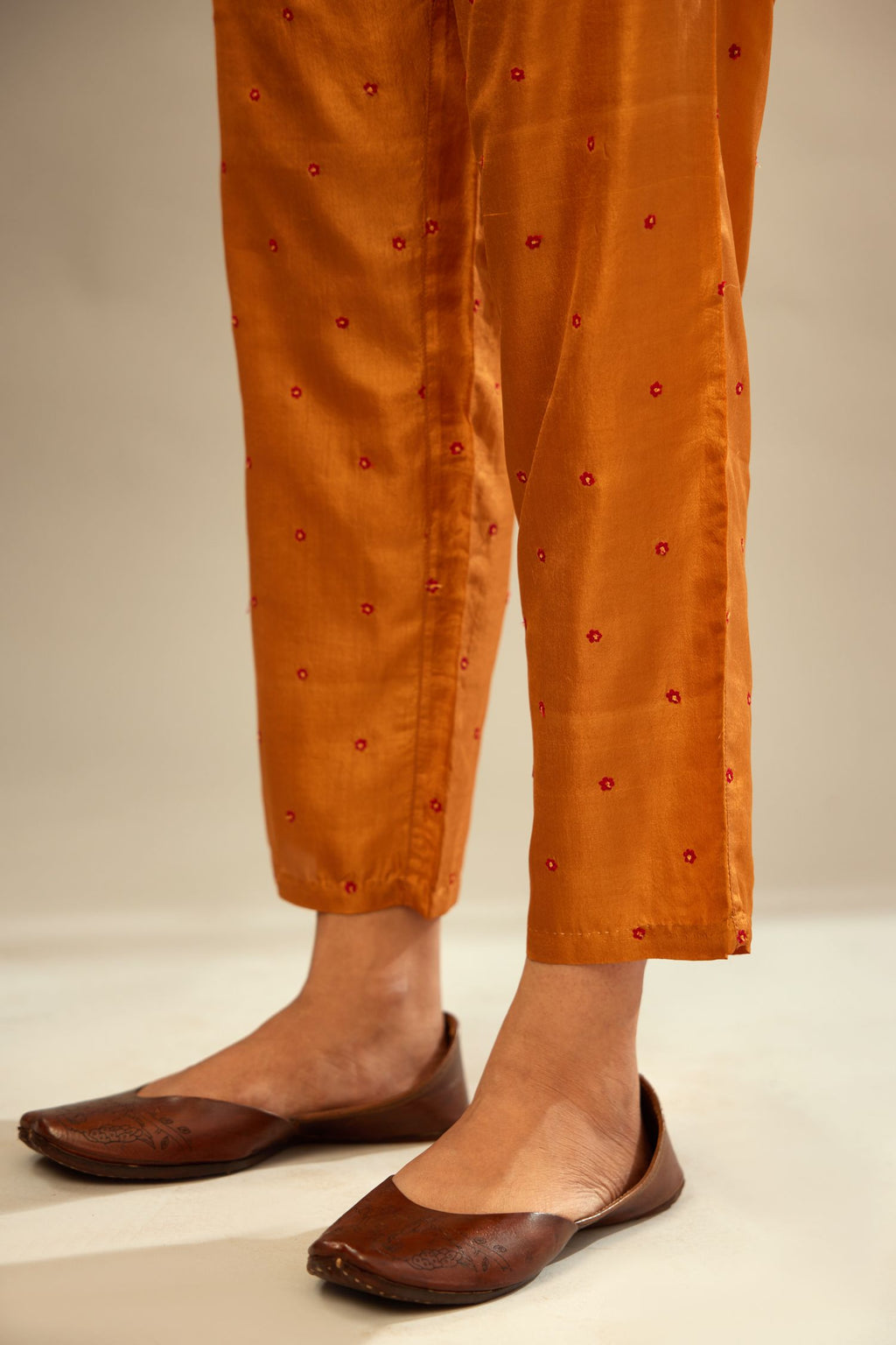 Mustard silk straight pants detailed with small flower embroidery at bottom.