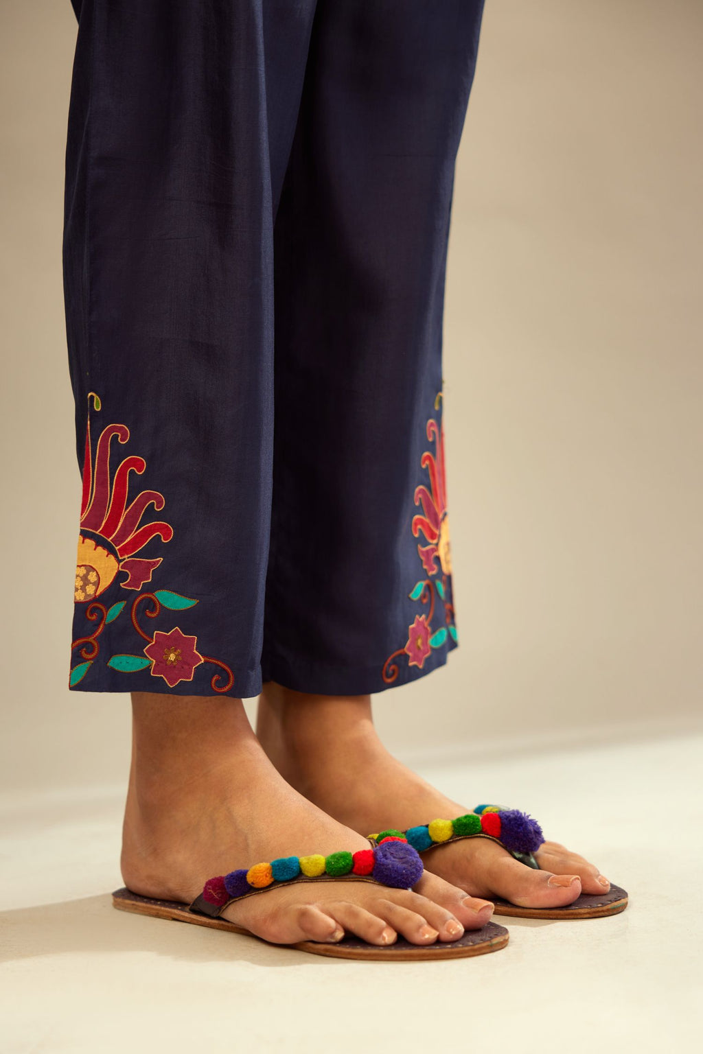 Indigo silk straight pants with multi colored appliqué at hem.
