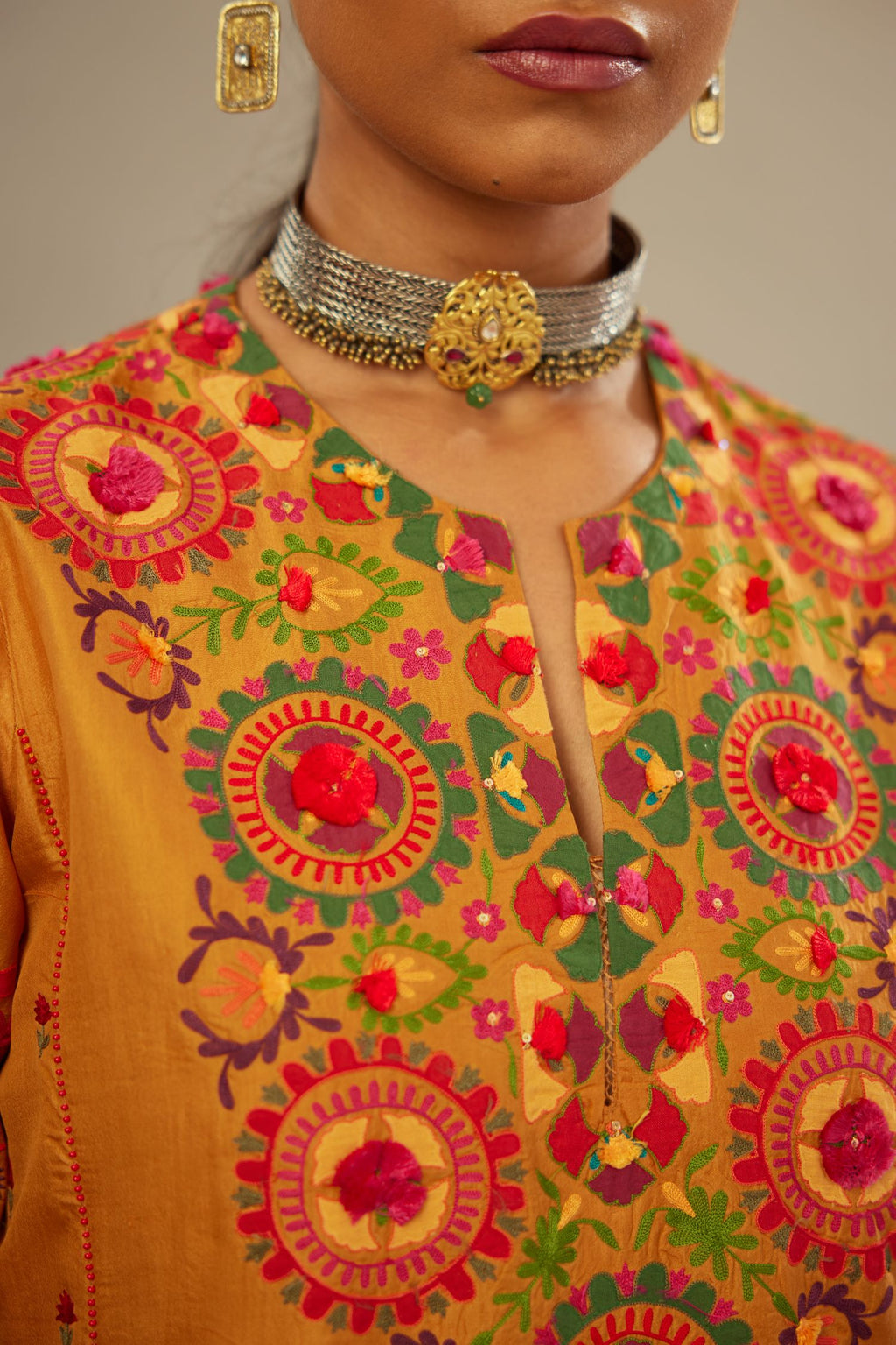 Mustard kalidar straight kurta set, fully embroidered with appliqué flowers, multi-colored aari threadwork and silk tassels.