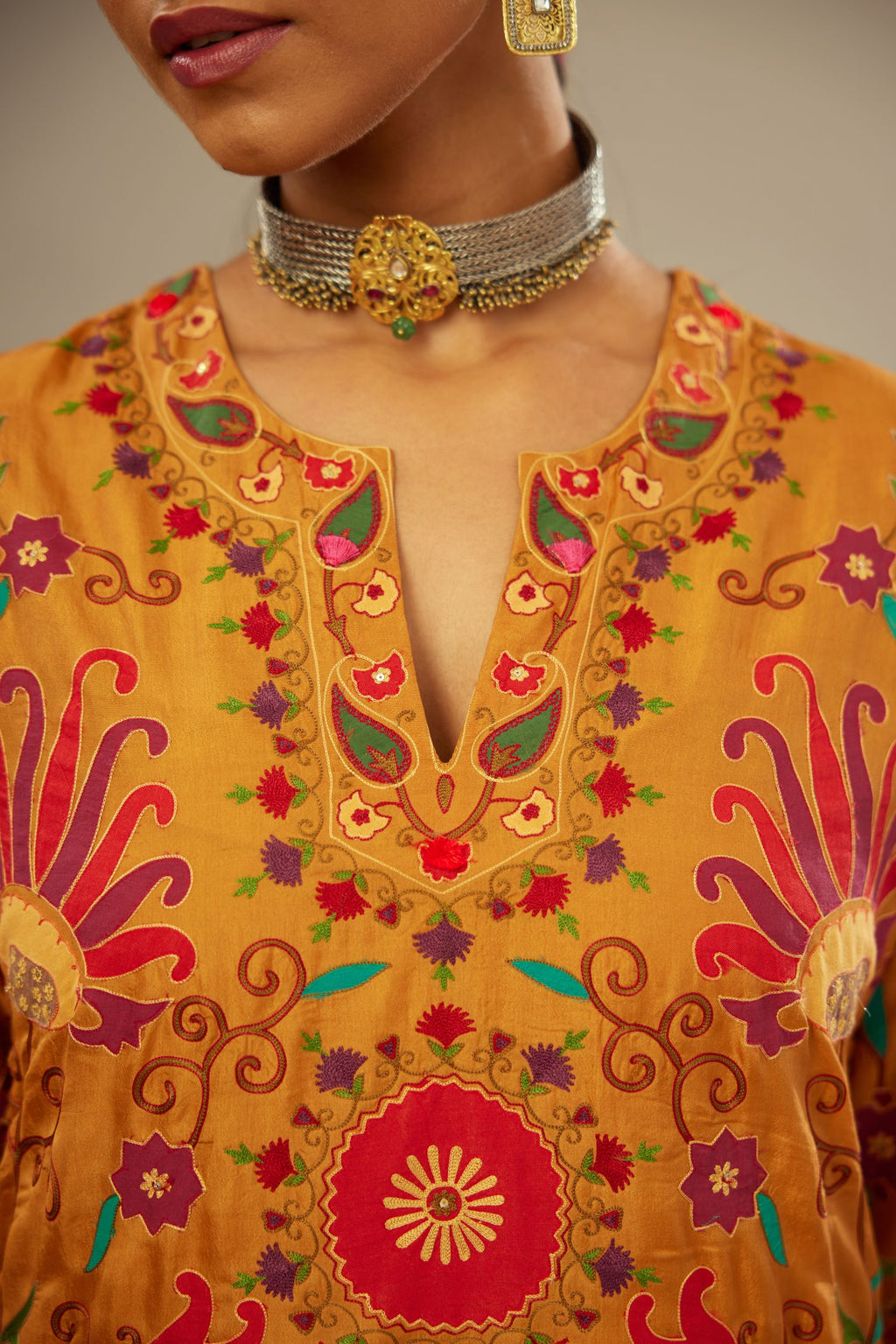Mustard straight kurta set, fully embroidered with bold appliqué flowers, multi-colored aari threadwork and silk tassels.