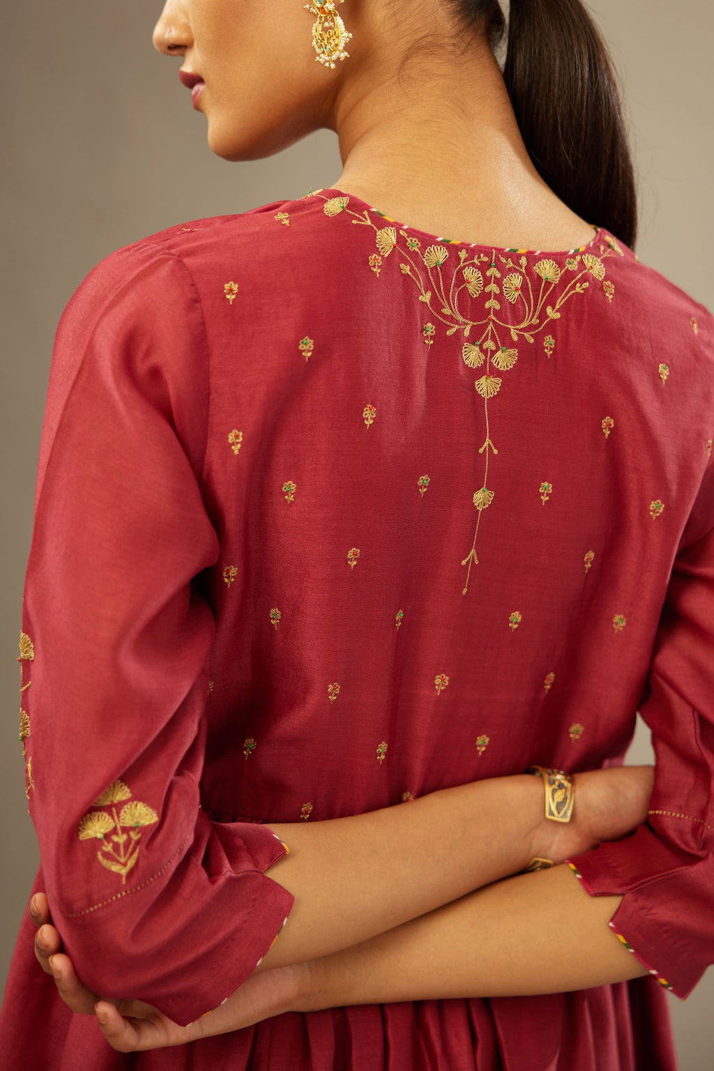 Deep wine long kurta set with wavy waistline detailed with golden zari embroidery