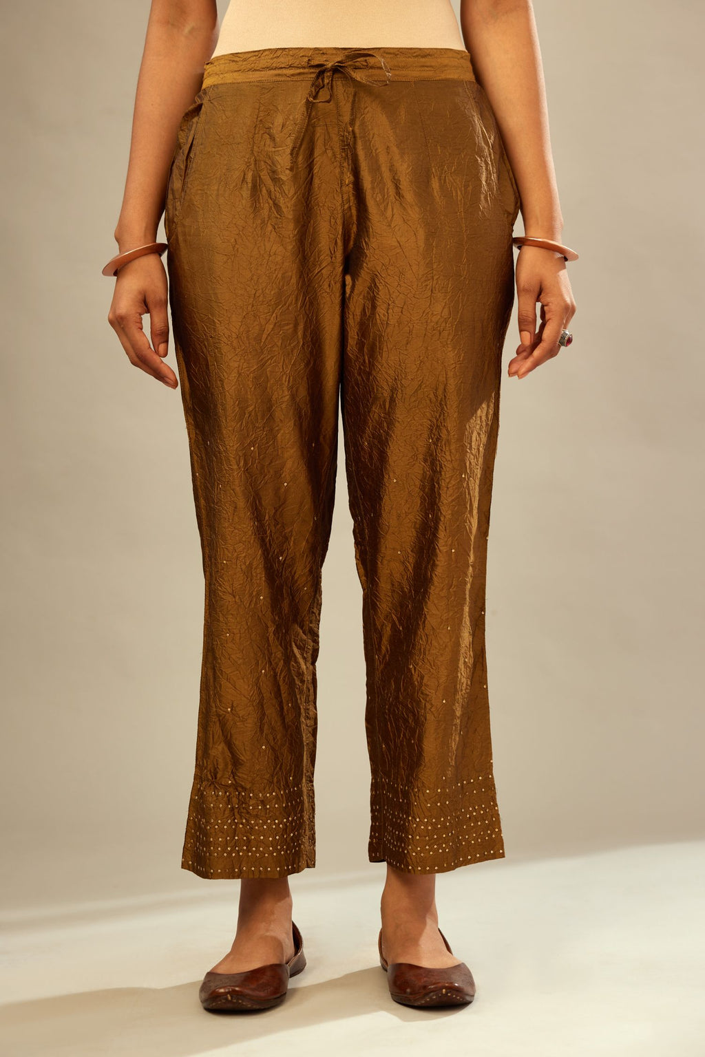Golden olive hand crushed pure silk straight pants with gold sequins at hem in horizontal lines formation and side pockets.