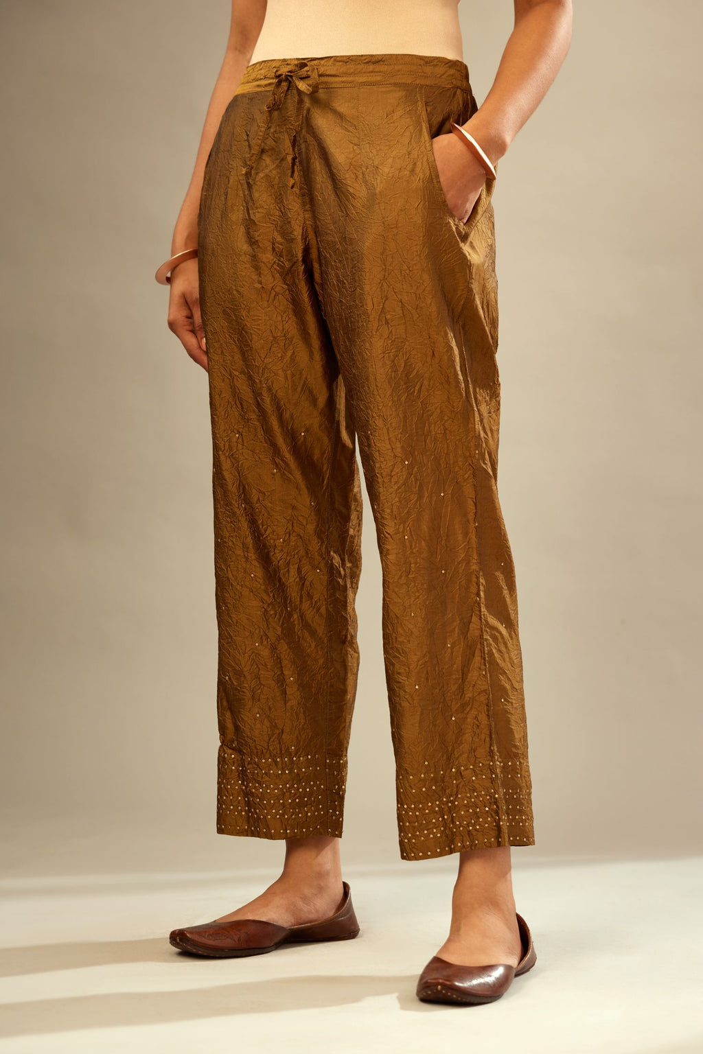 Golden olive hand crushed pure silk straight pants with gold sequins at hem in horizontal lines formation and side pockets.