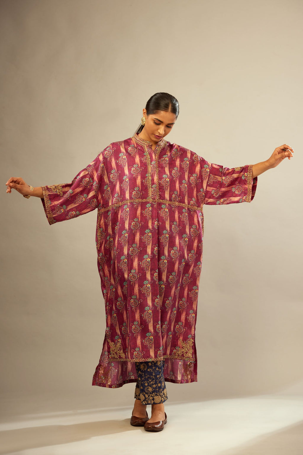 Deep wine digital printed dori embroidered free size silk kaftan, highlighted with gold sequin handwork. Paired with navy blue fine silk straight pants with heavy golden zari and dori embroidery at bottom.