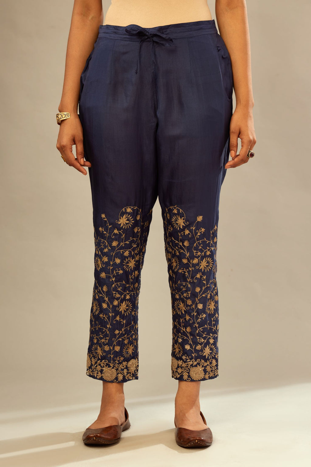 Navy blue fine silk straight pants with heavy golden zari and dori embroidery at bottom.