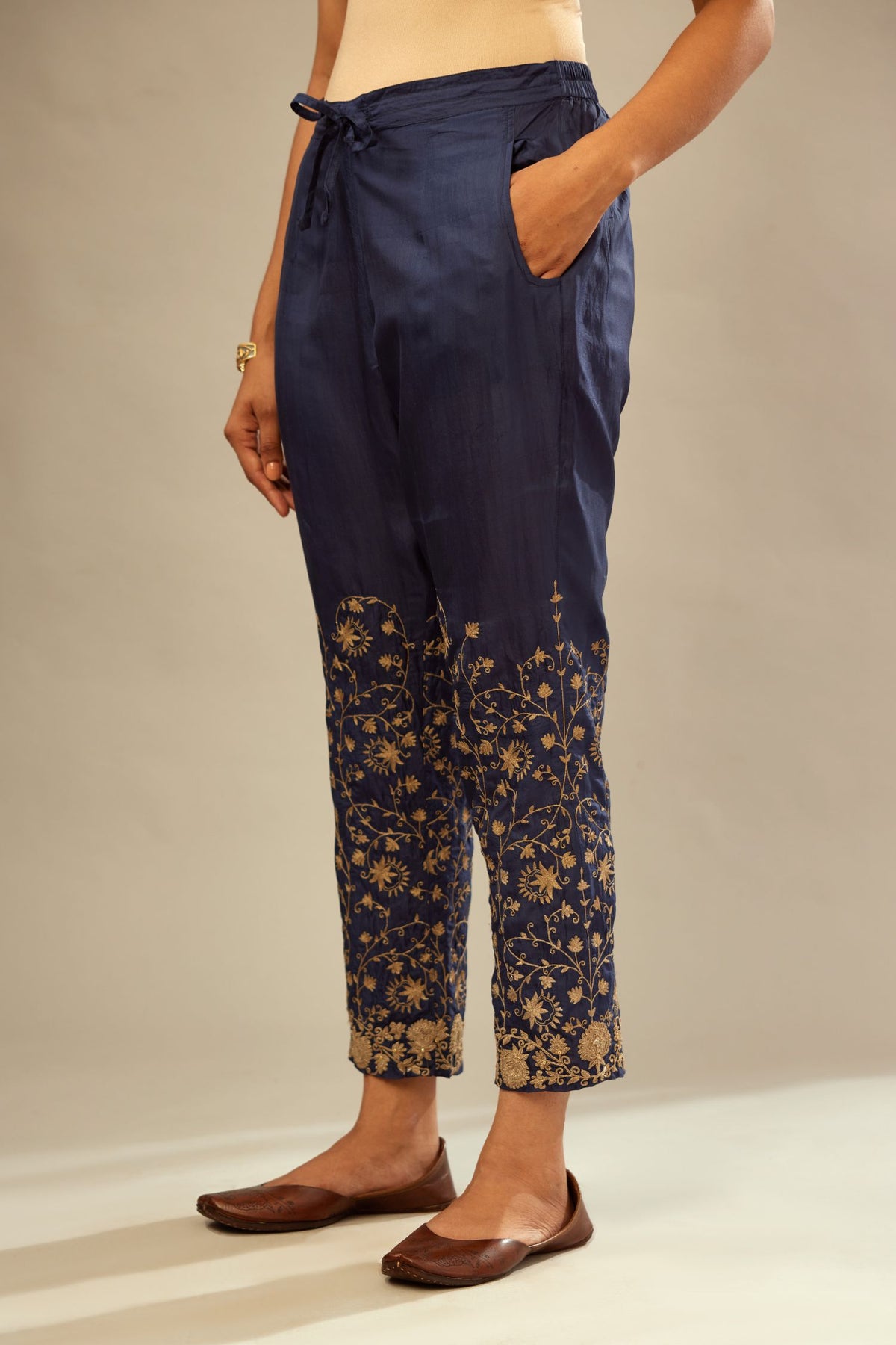 Navy blue fine silk straight pants with heavy golden zari and dori embroidery at bottom.