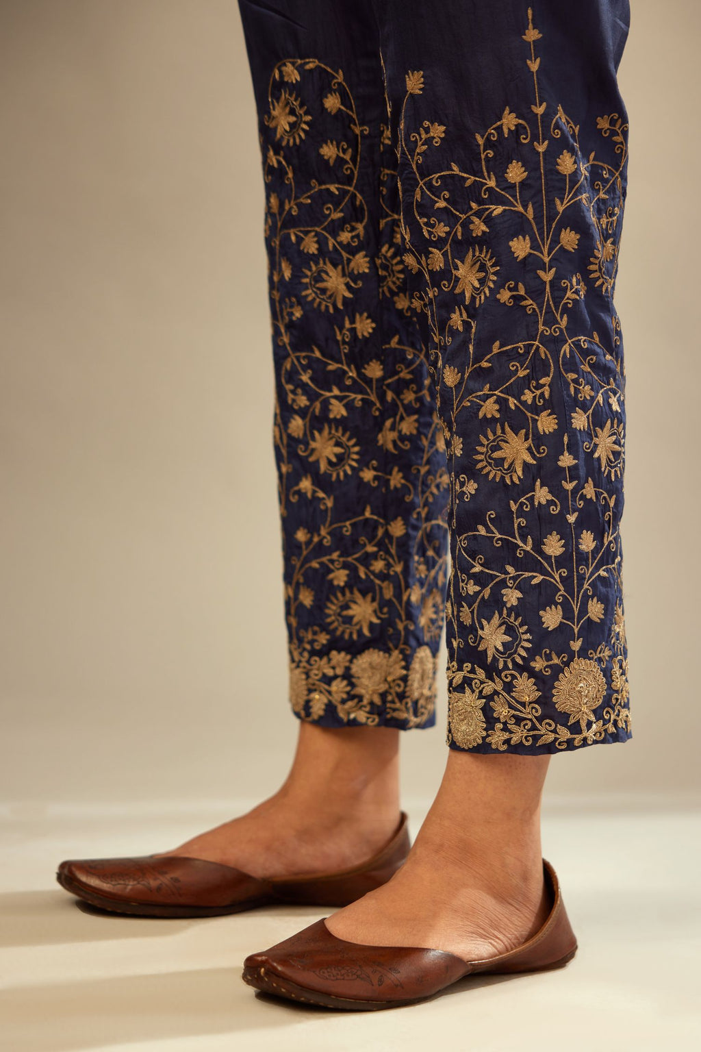 Navy blue fine silk straight pants with heavy golden zari and dori embroidery at bottom.