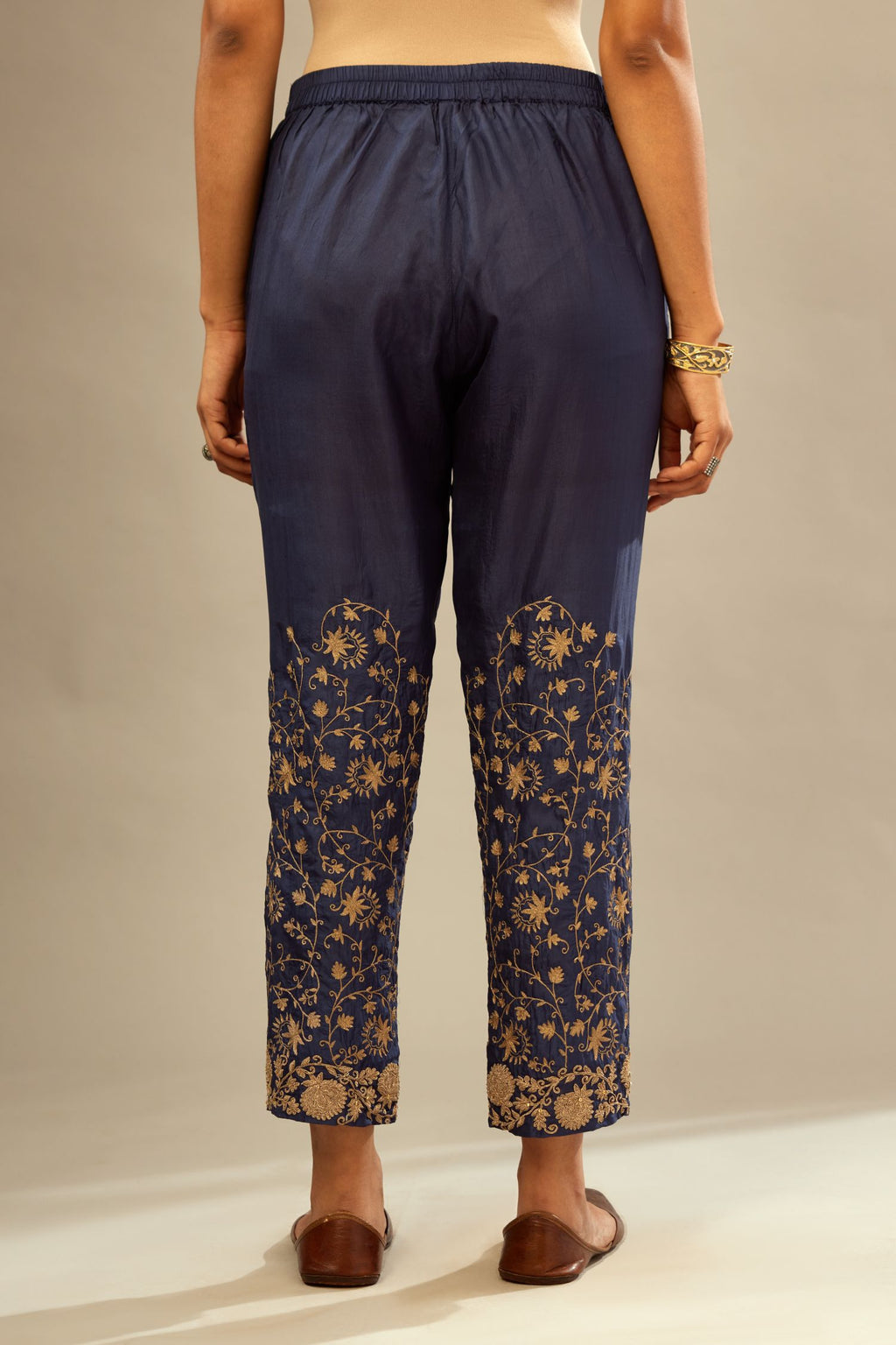 Navy blue fine silk straight pants with heavy golden zari and dori embroidery at bottom.