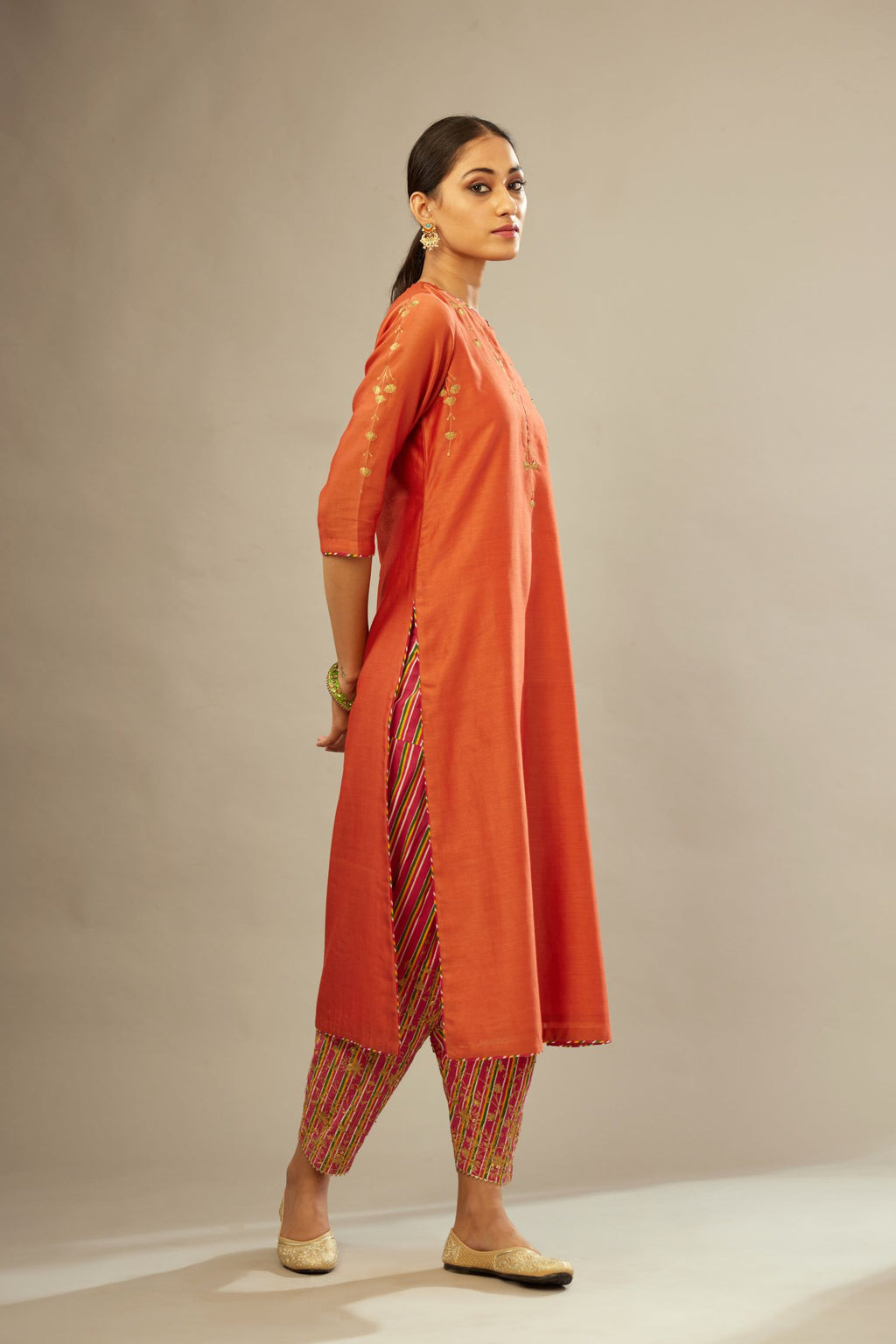 Silk Chanderi straight kurta set detailed with golden zari and multi striped piping on the edges.