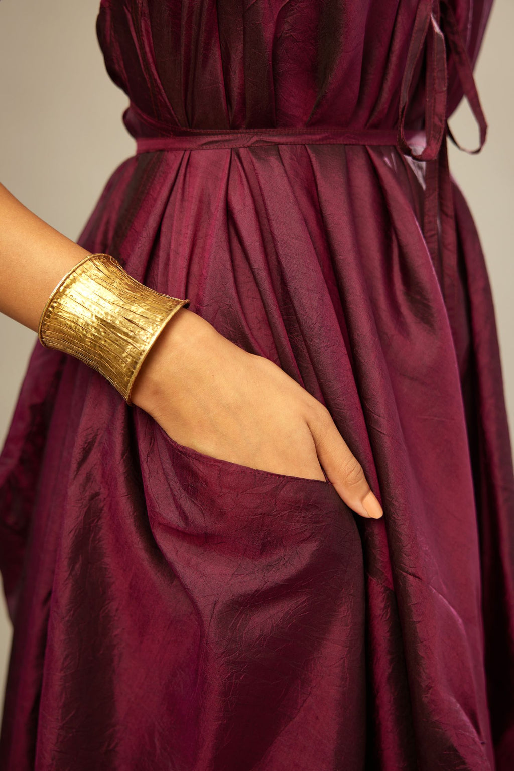 Wine silk long free size dress with asymmetric hem and side pockets, paired with navy blue silk velvet short jacket with light gold dori embroidery all-over the jacket.