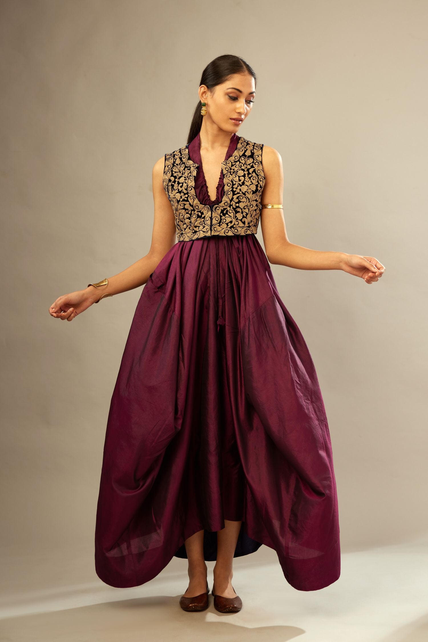 Wine silk long free size dress with asymmetric hem and side pockets, paired with navy blue silk velvet short jacket with light gold dori embroidery all-over the jacket.