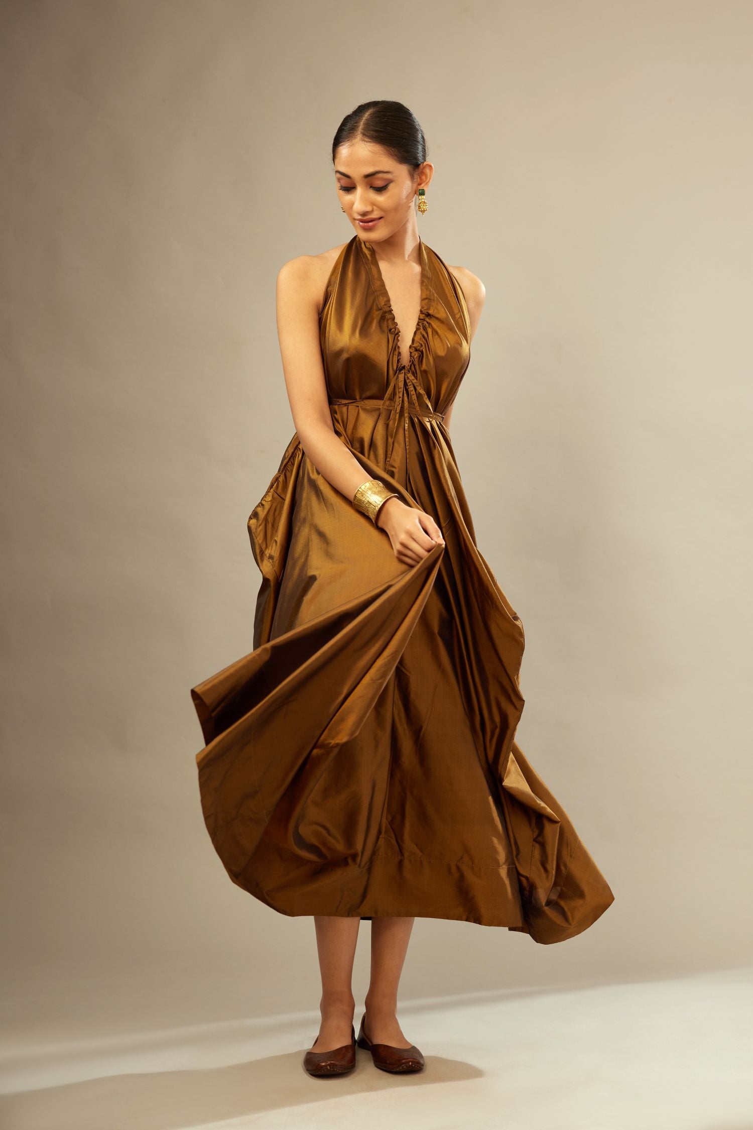 Golden olive silk long free size dress with asymmetric hem and side pockets, paired with navy blue silk velvet short jacket with light gold dori embroidery all-over the jacket.