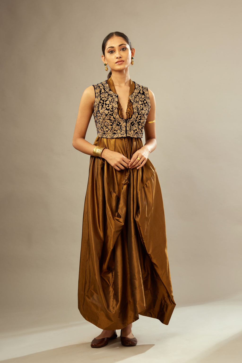 Golden olive silk long free size dress with asymmetric hem and side pockets, paired with navy blue silk velvet short jacket with light gold dori embroidery all-over the jacket.
