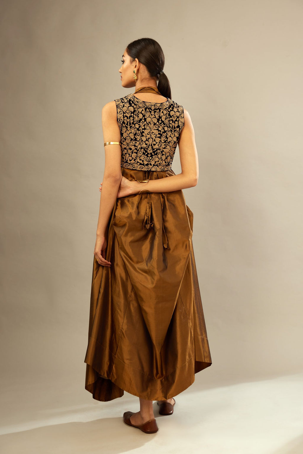 Golden olive silk long free size dress with asymmetric hem and side pockets, paired with navy blue silk velvet short jacket with light gold dori embroidery all-over the jacket.