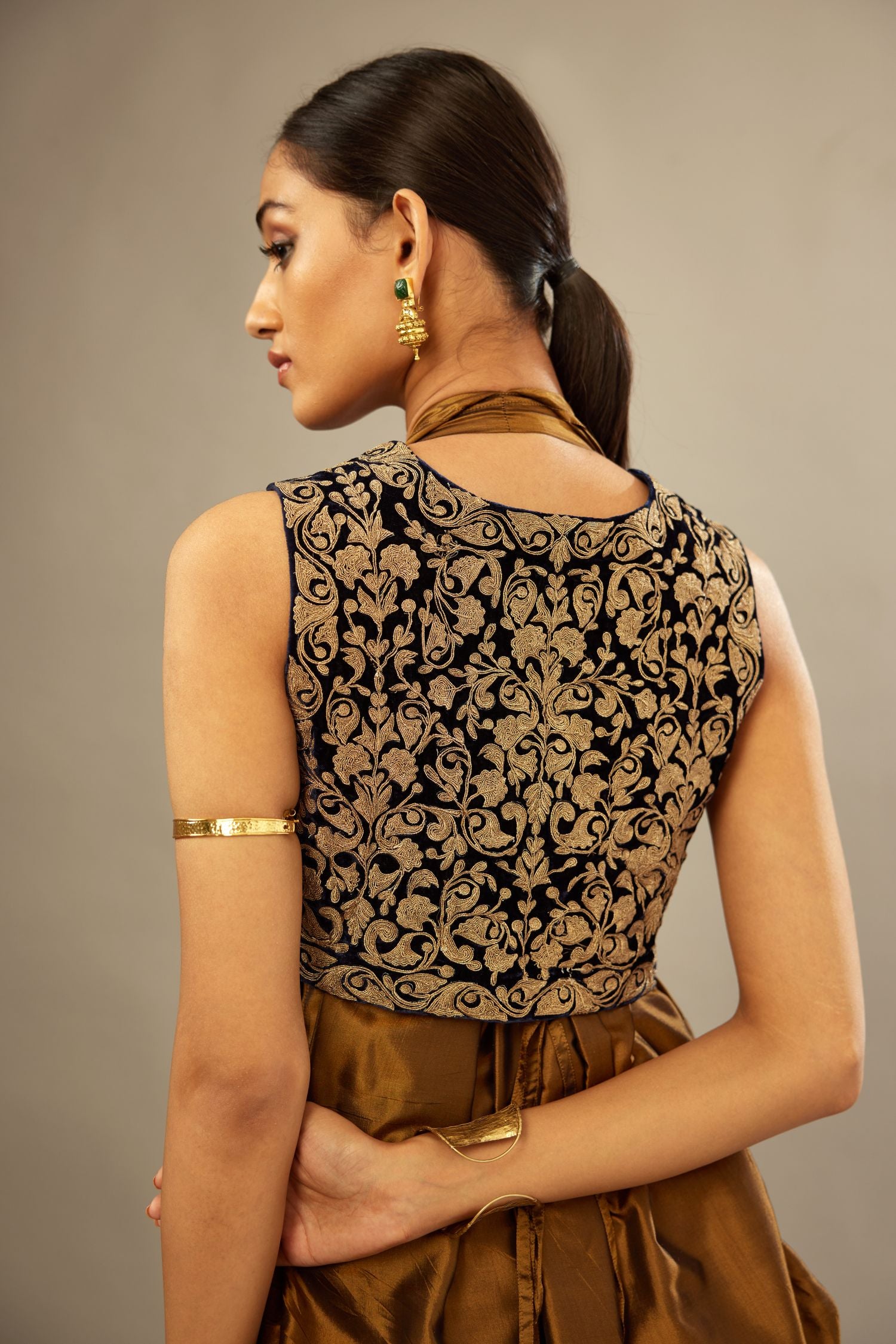 Golden olive silk long free size dress with asymmetric hem and side pockets, paired with navy blue silk velvet short jacket with light gold dori embroidery all-over the jacket.
