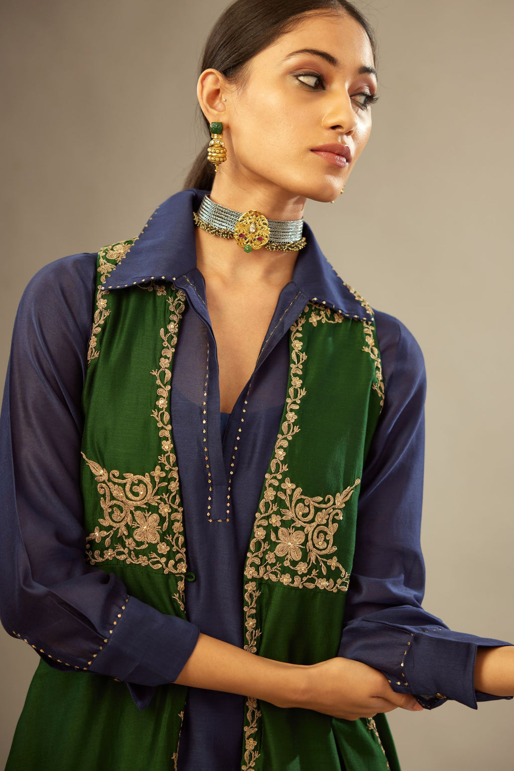 Green long silk chanderi front open sleeveless jacket set with gold dori embroidery detailing, highlighted with gold sequin work.