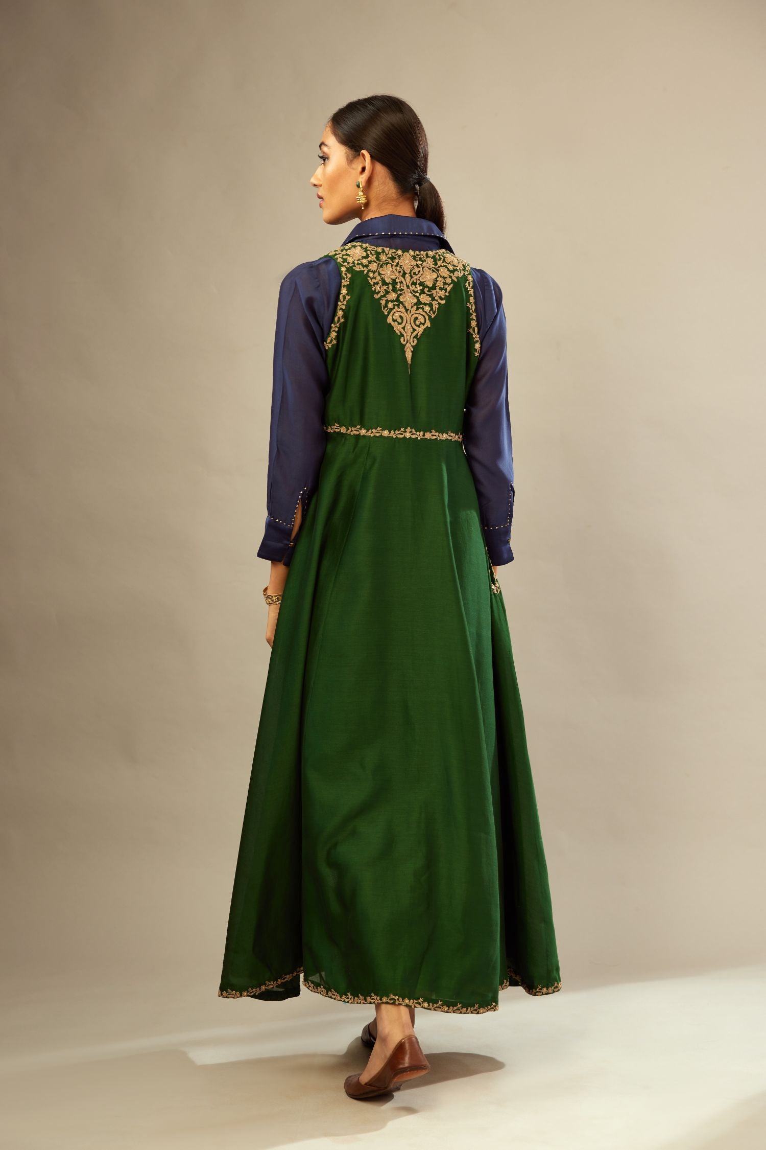 Green long silk chanderi front open sleeveless jacket set with gold dori embroidery detailing, highlighted with gold sequin work.