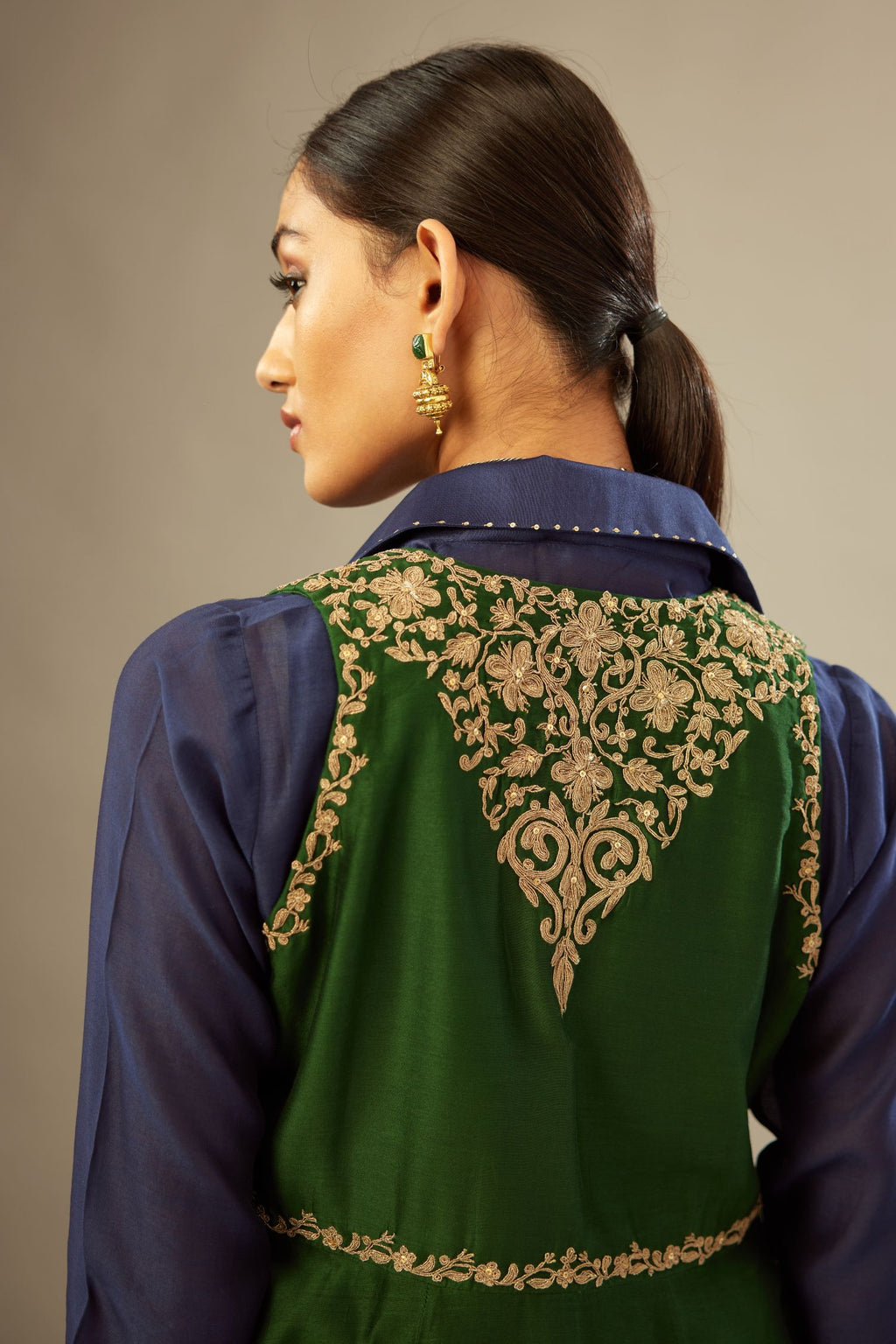 Green long silk chanderi front open sleeveless jacket set with gold dori embroidery detailing, highlighted with gold sequin work.